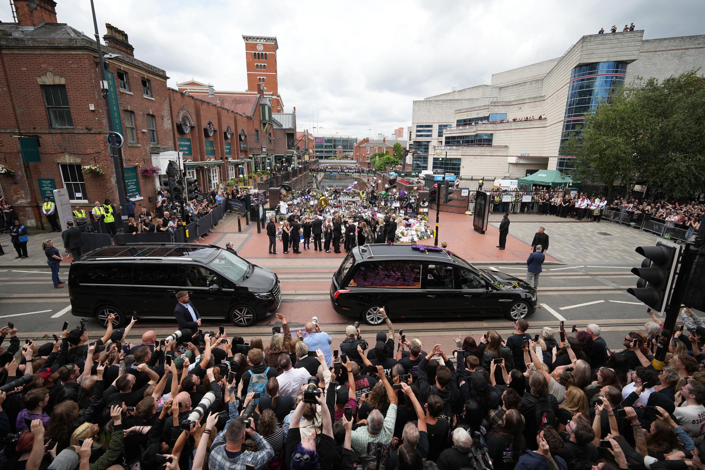 Sharon Osbourne, Jack Osbourne, Kelly Osbourne and Aimee Osbourne view tributes to the late Ozzy Osbourne from fans at Black Sabbath Bench and Bridge as his funeral cortege travels through his home city of Birmingham on July 30, 2025 in Birmingham, England. | Source: Getty Images