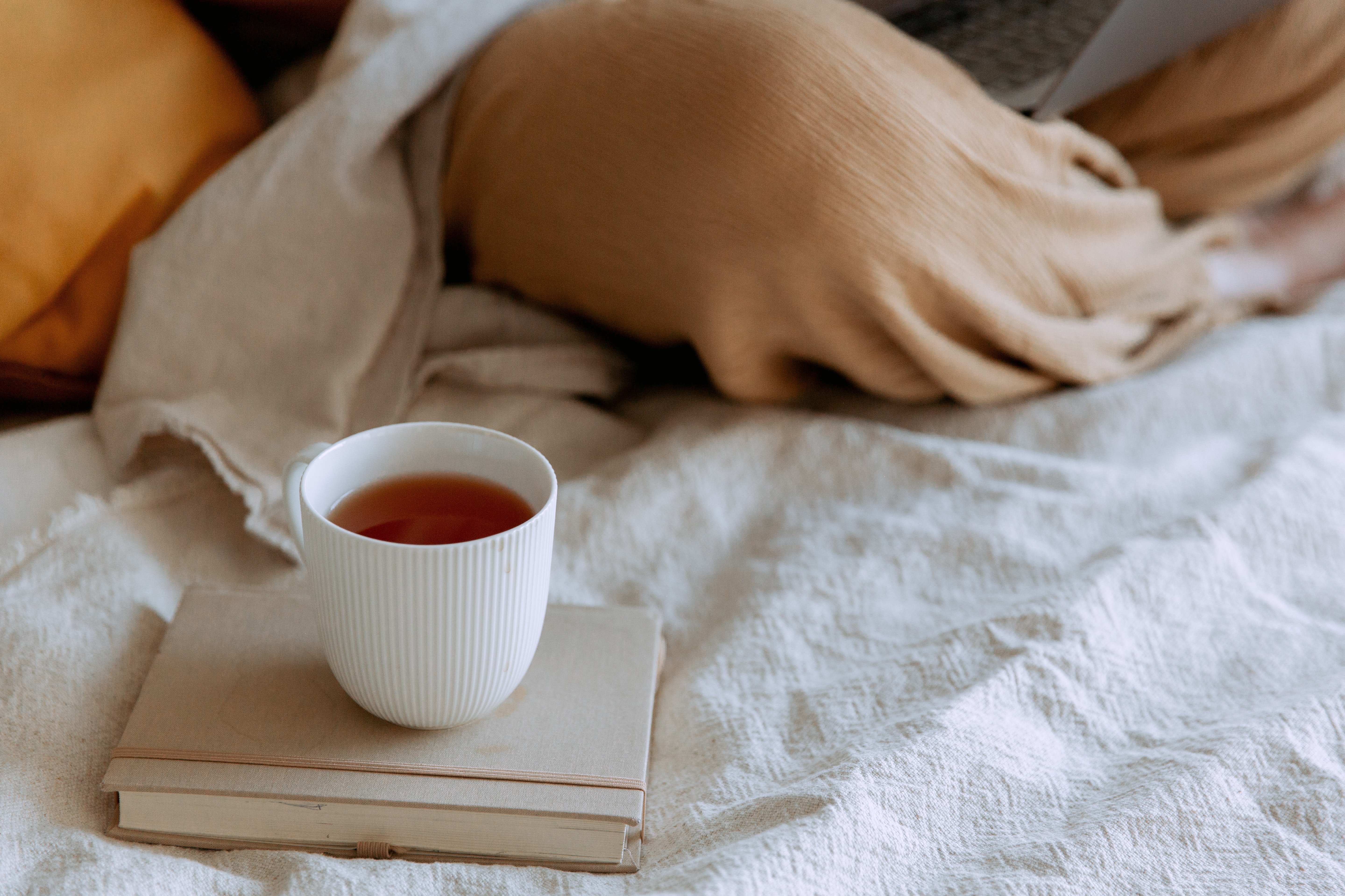 A cup of tea on a bed | Source: Pexels