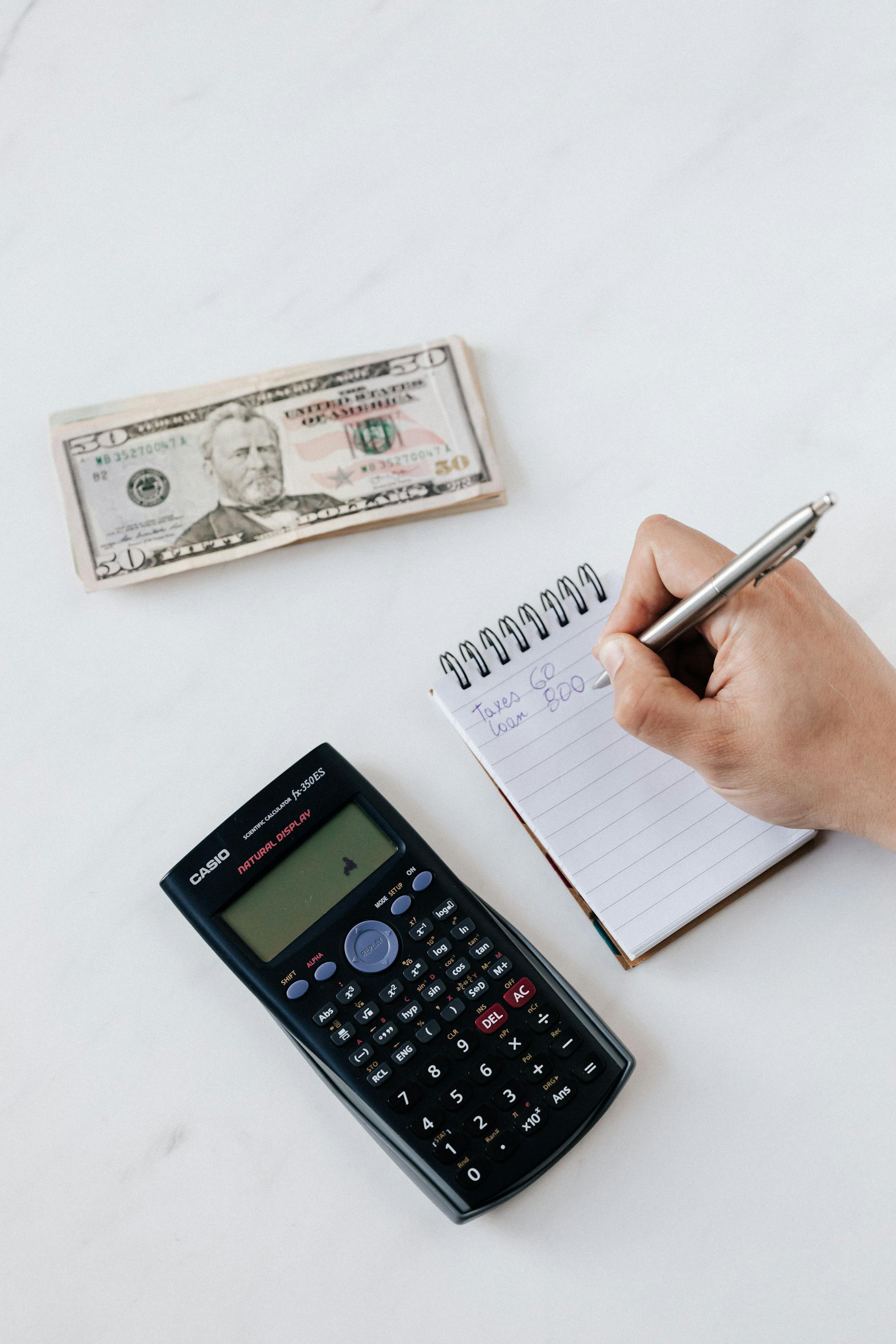 A man calculating expenses | Source: Pexels