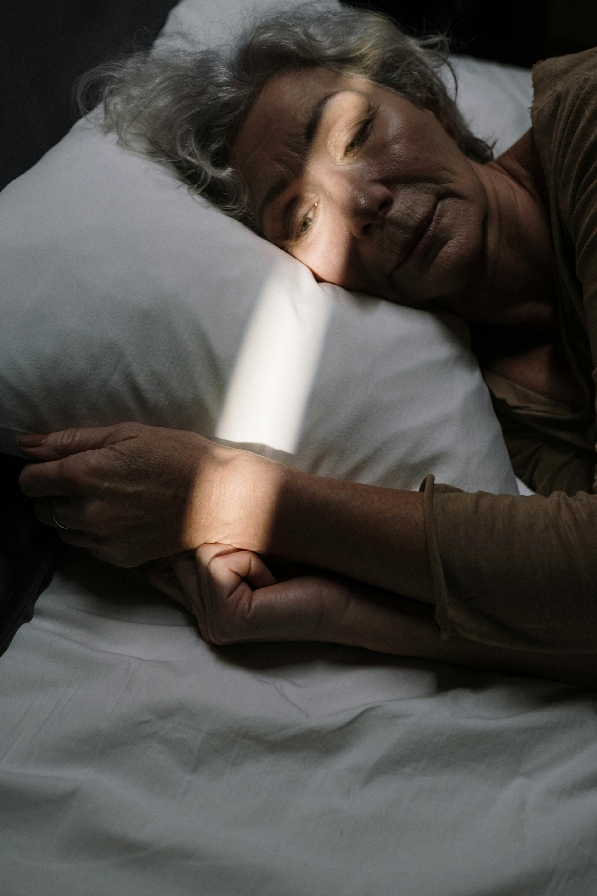 A senior woman lying awake in bed | Source: Pexels