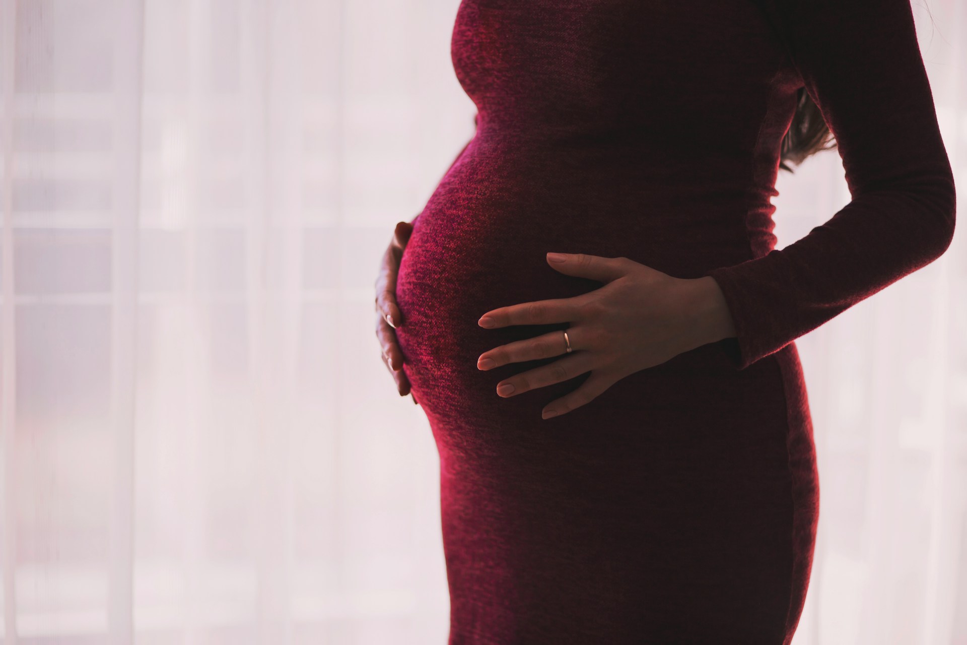 Una foto recortada de una mujer embarazada sosteniendo su pancita | Fuente: Unsplash