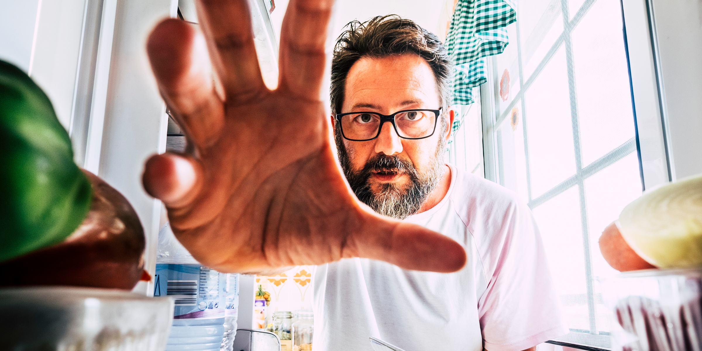 Man grabbing food from the fridge | Source: Shutterstock
