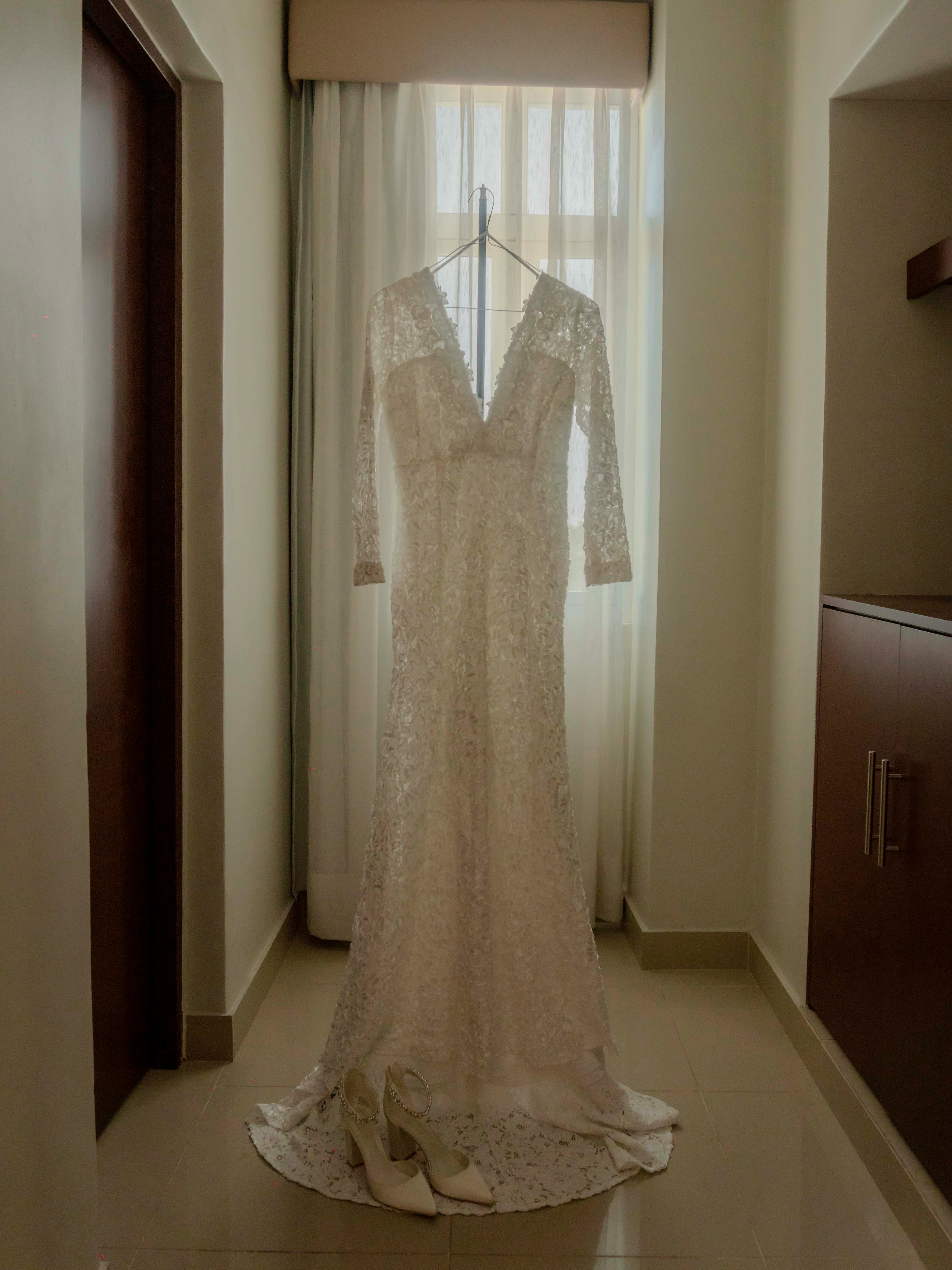 Wedding gown hanging infront of a window | Source: Unsplash