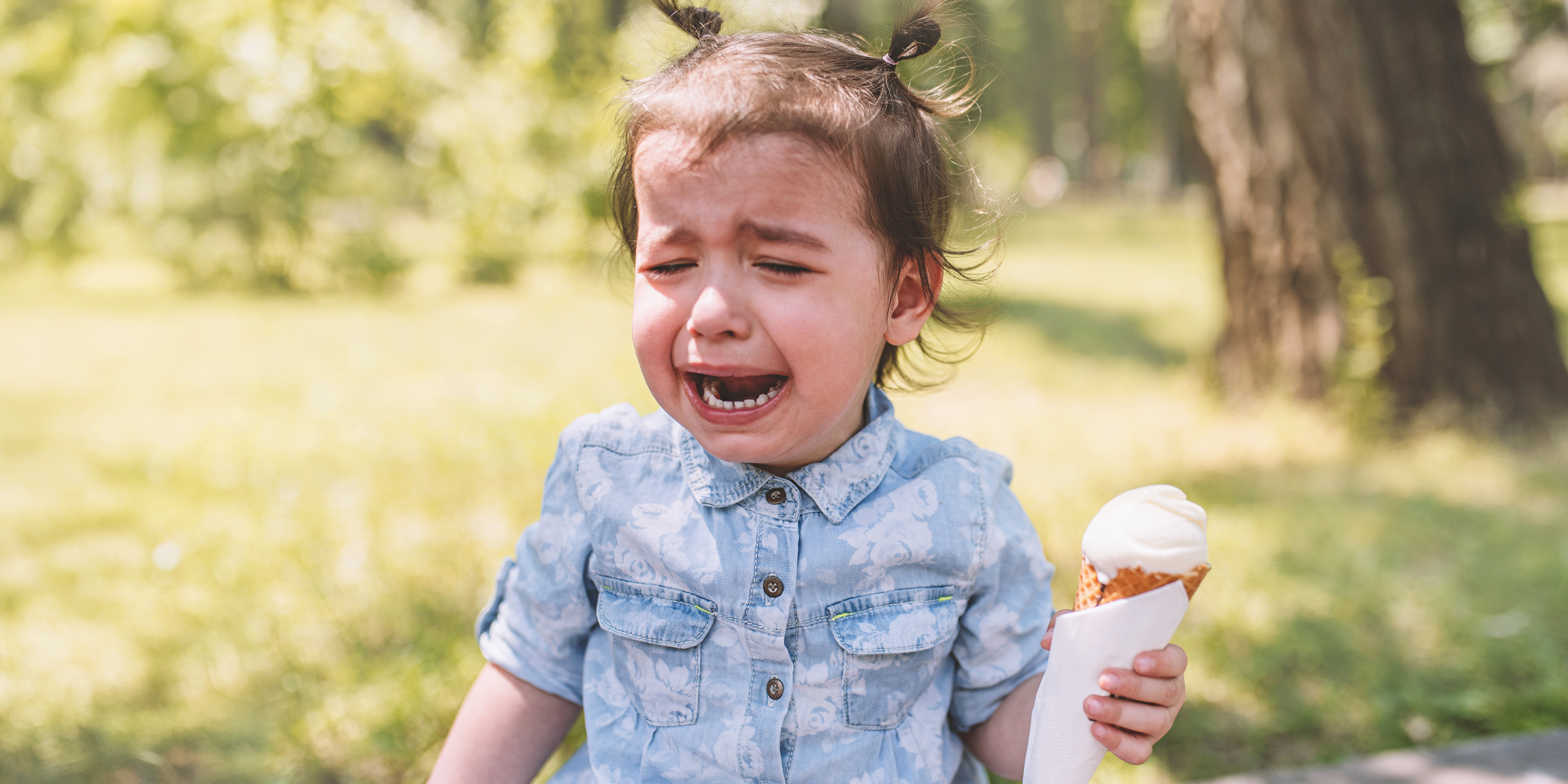 A crying little girl holding an ice cream cone | Source: Shutterstock
