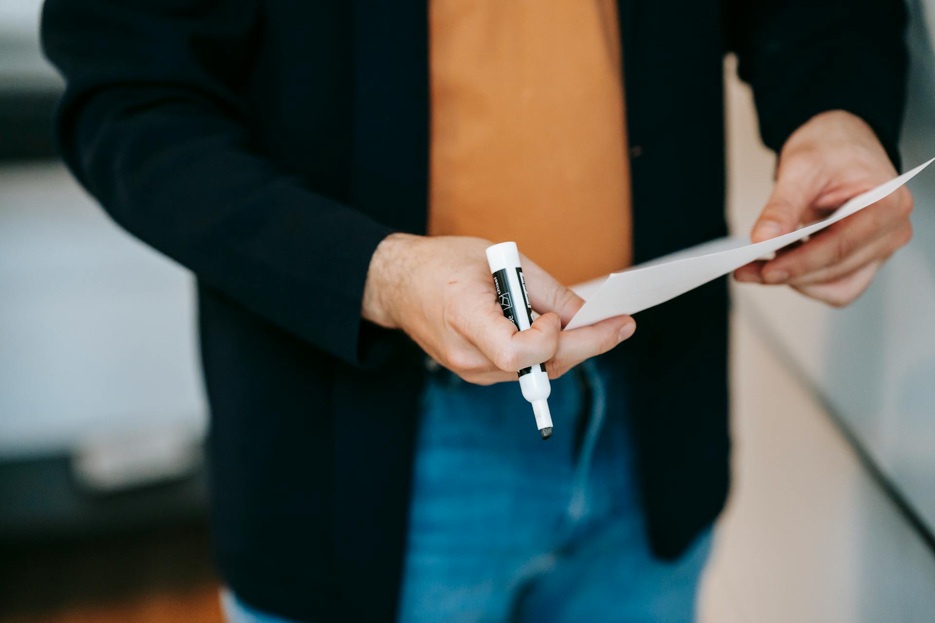 A man holding a marker and a piece of paper | Source: Pexels