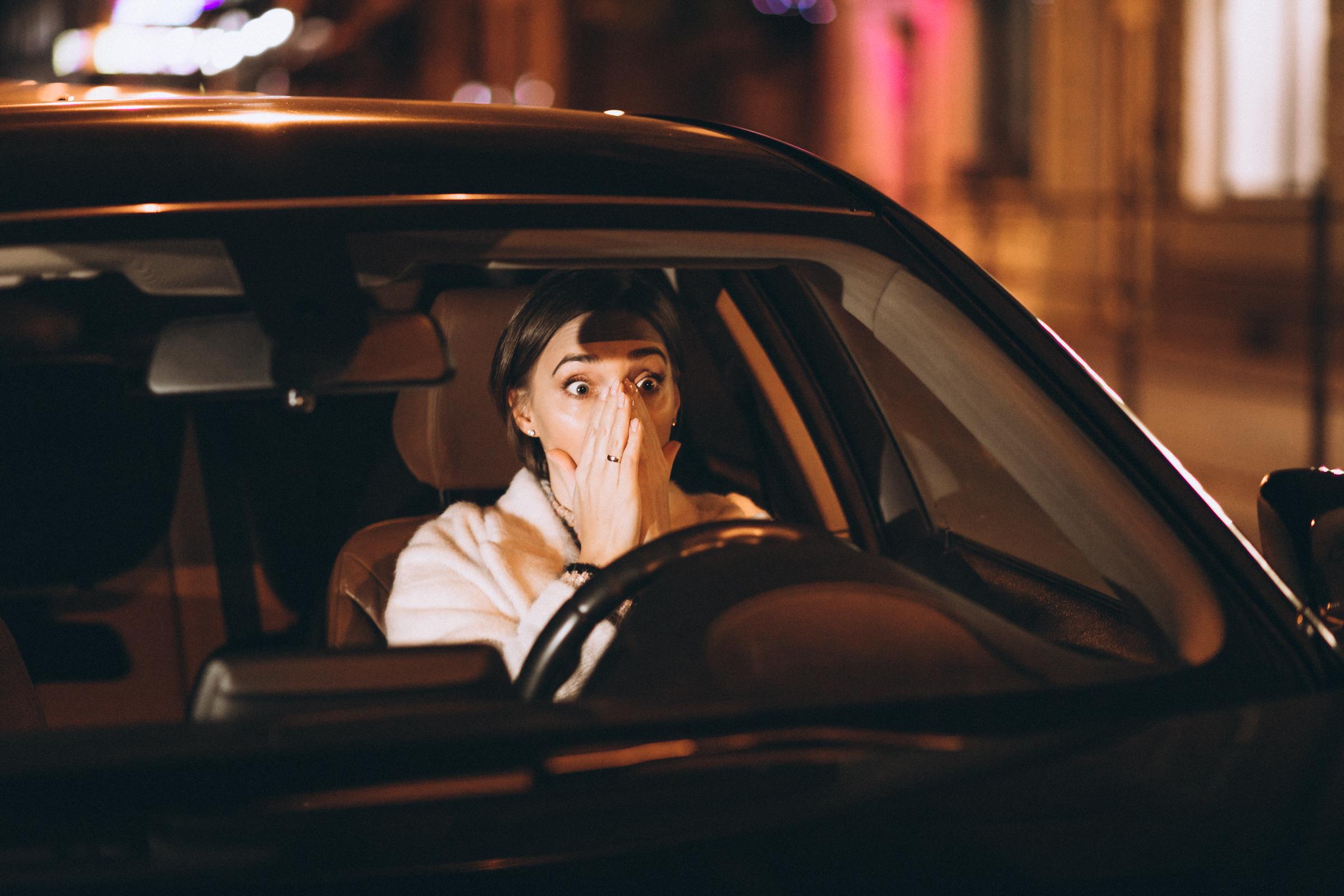 A startled woman sitting in a car | Source: Freepik