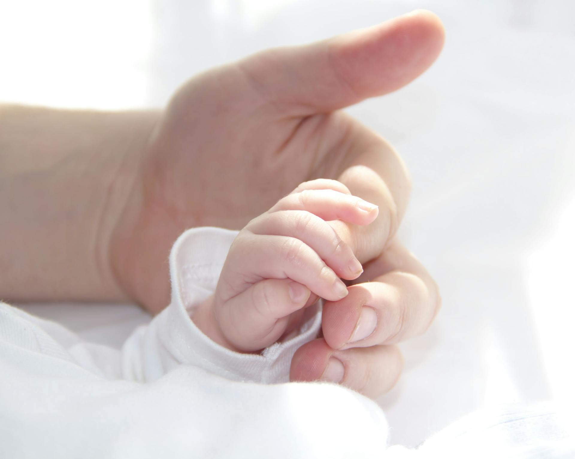 A baby holding a man's finger | Source: Pexels