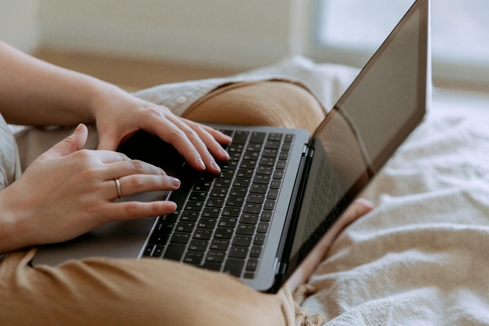 Uma mulher usando um laptop na cama | Fonte: Pexels