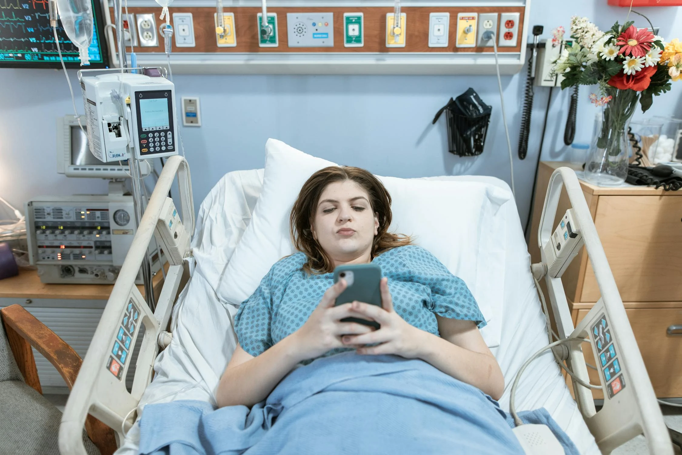 A woman on her phone in a hospital bed | Source: Pexels