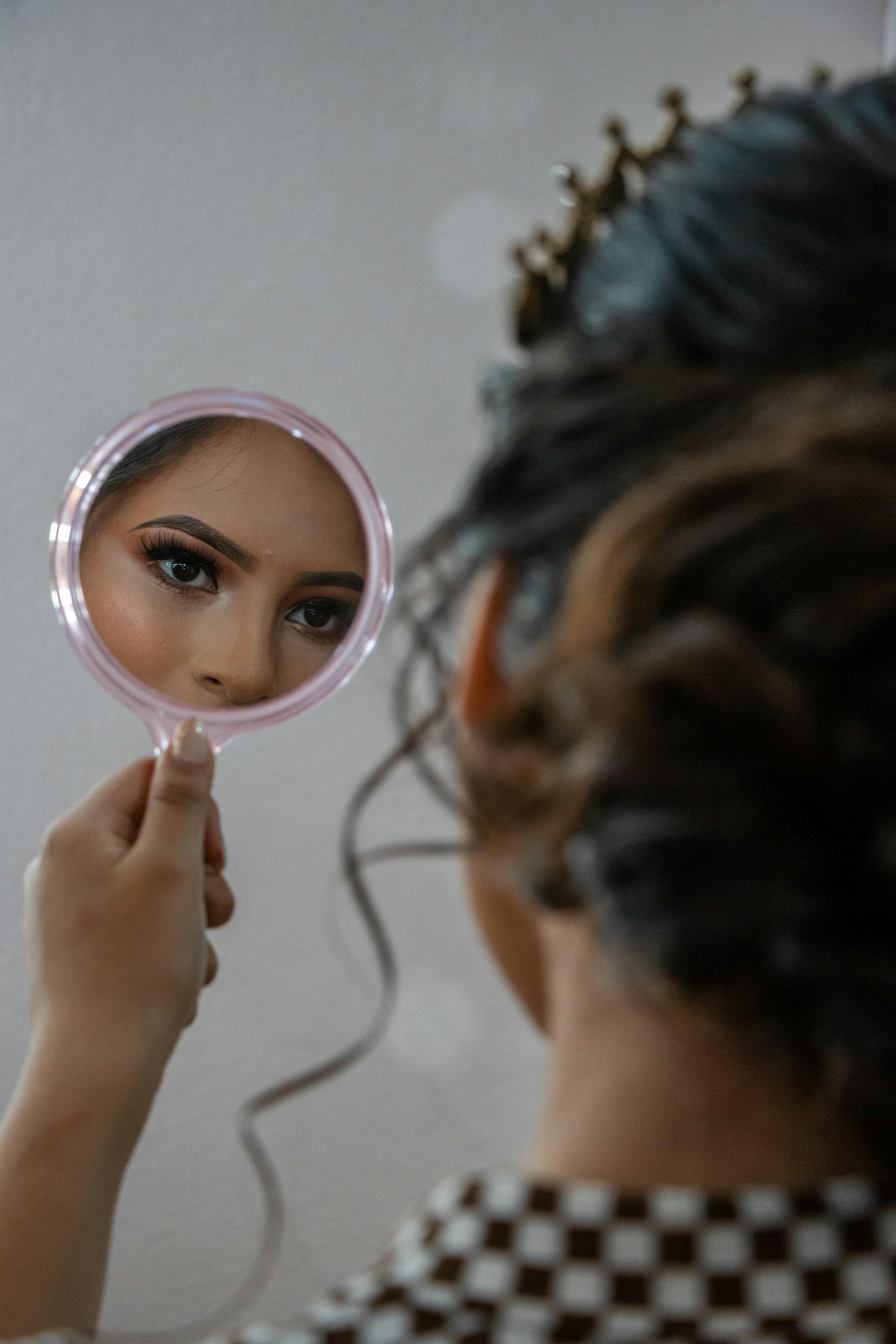 A woman staring at her reflection in the mirror | Source: Unsplash