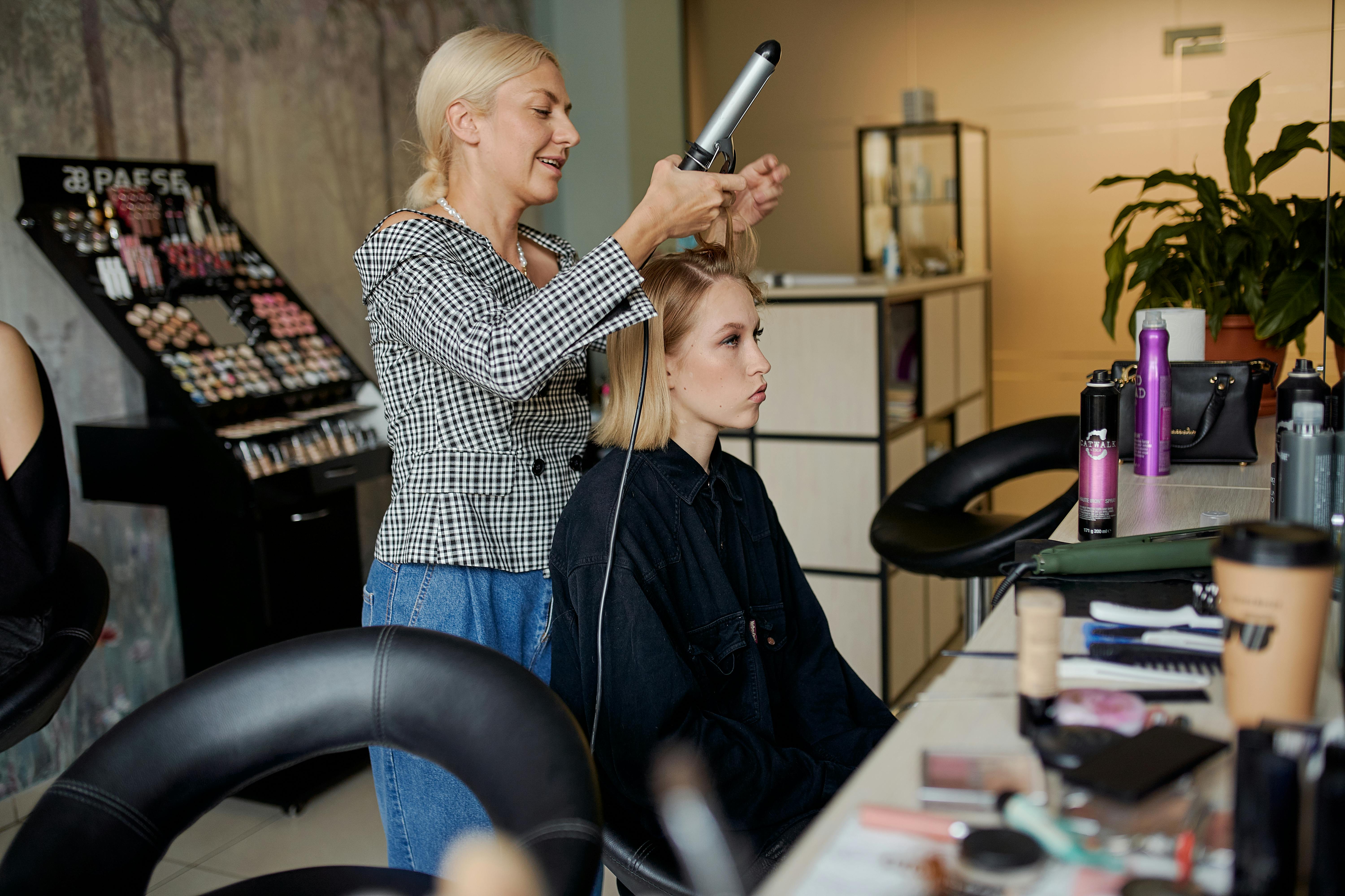 A hairdresser straightening a client's hair | Source: Pexels