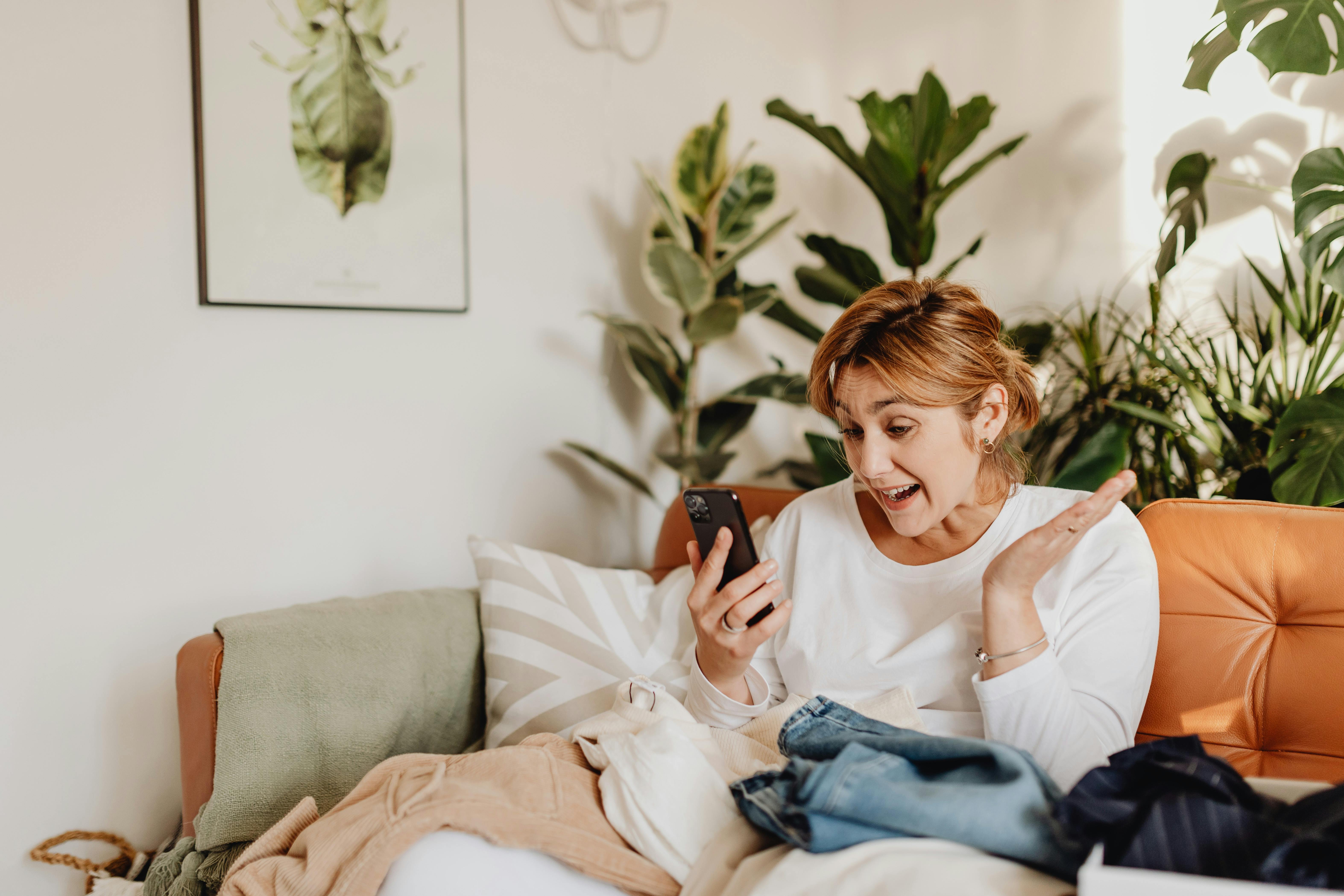 An excited woman looking at her phone | Source: Pexels