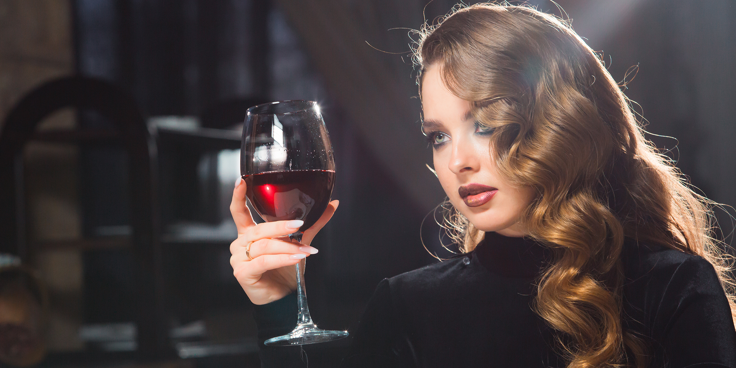 A woman holding a wine glass | Source: Shutterstock