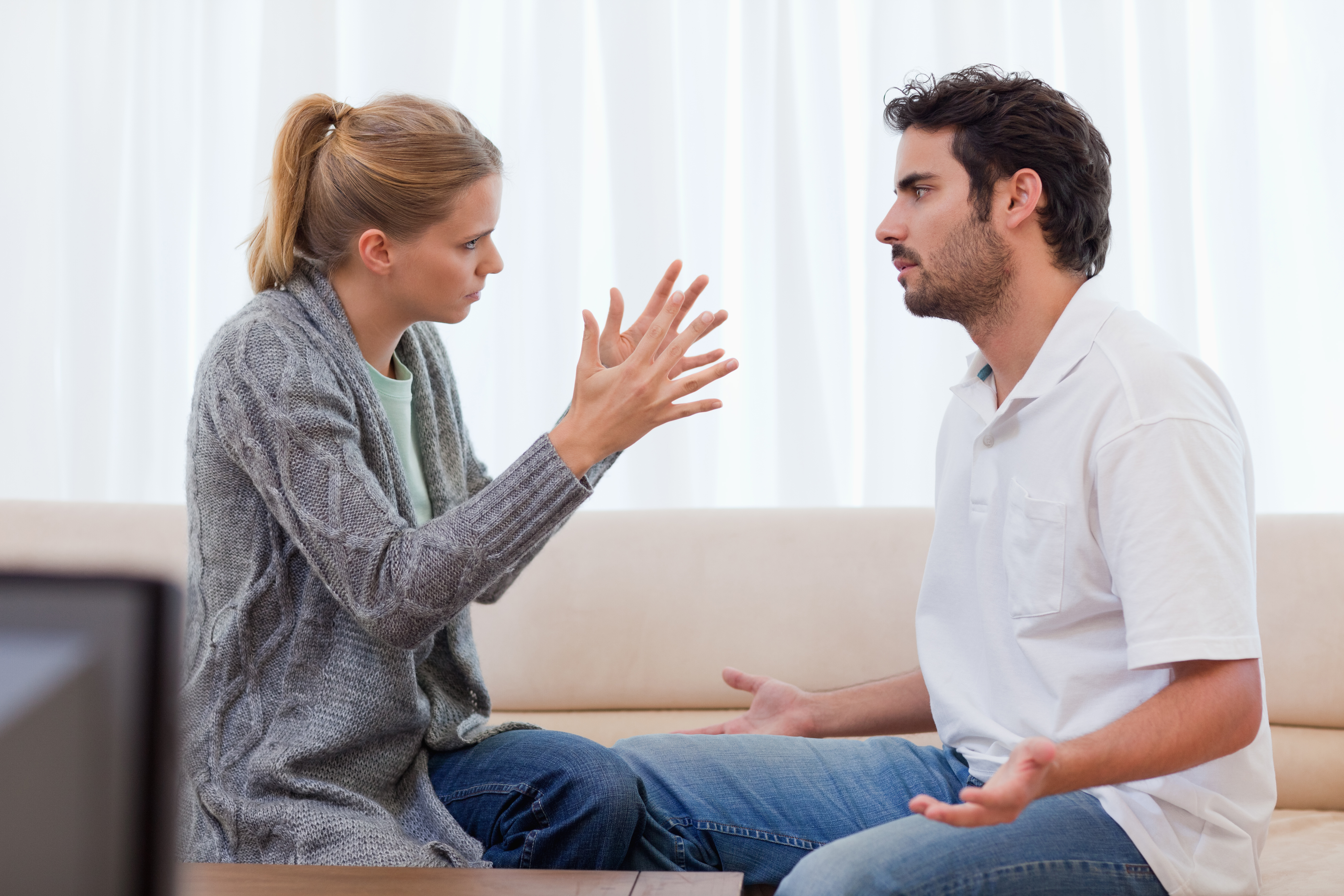 A man and a woman arguing in the living room | Source: Shutterstock