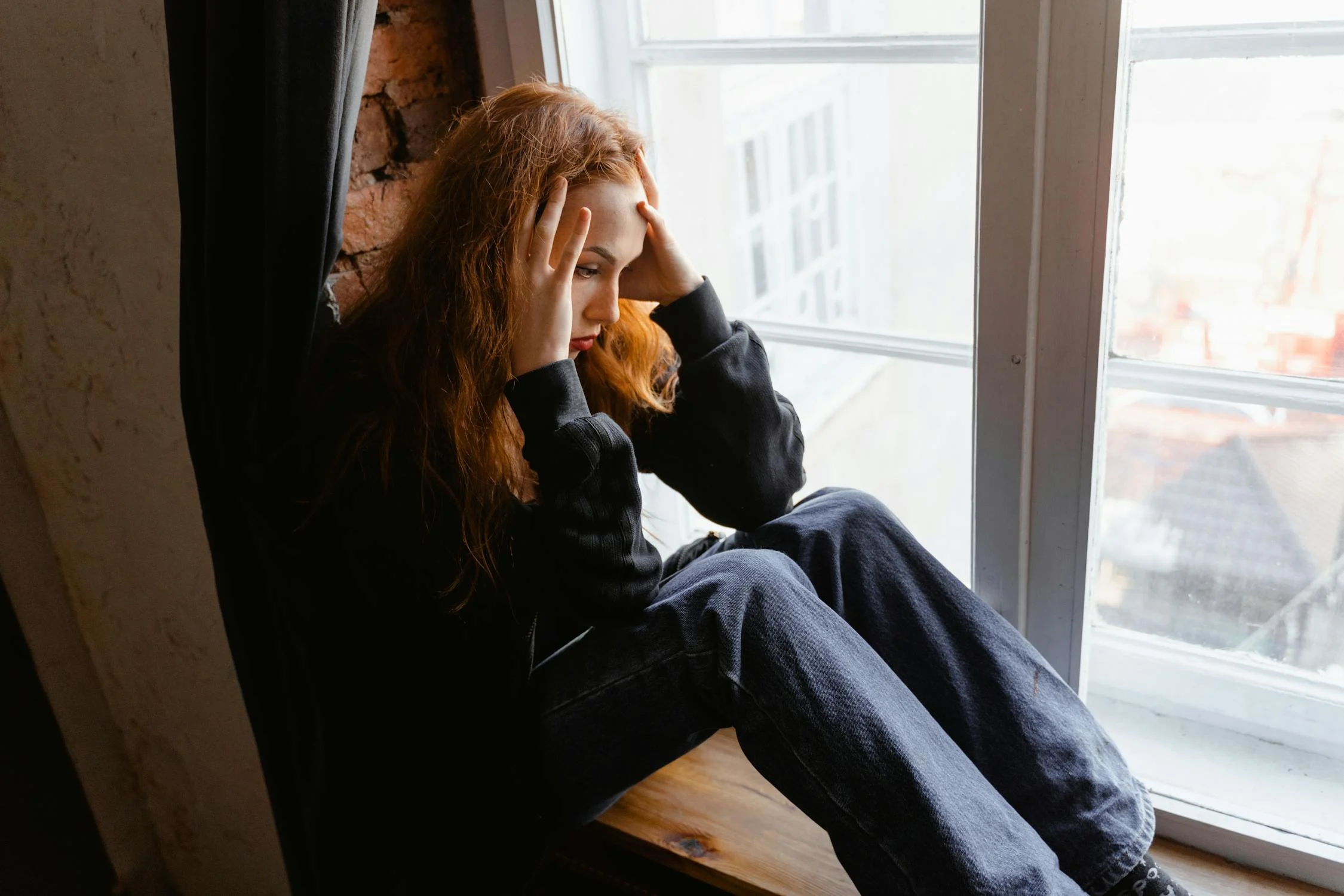 A shocked woman sitting in her living room | Source: Pexels