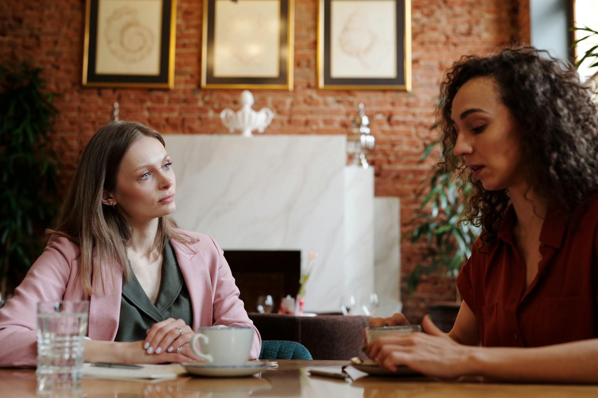 Two women talking while having coffee in a restaurant | Source: Pexels