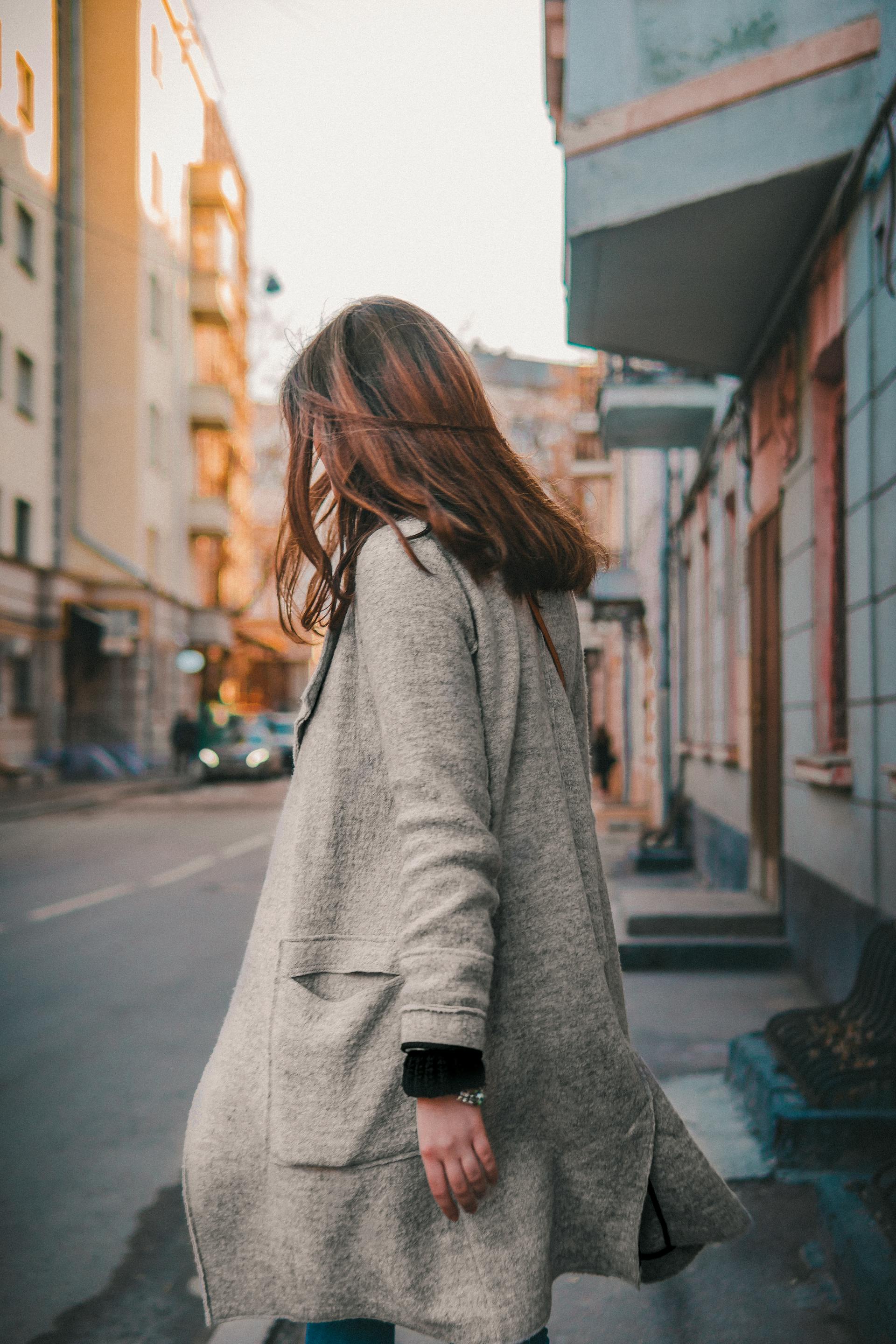A woman in a gray coat walking away | Source: Pexels