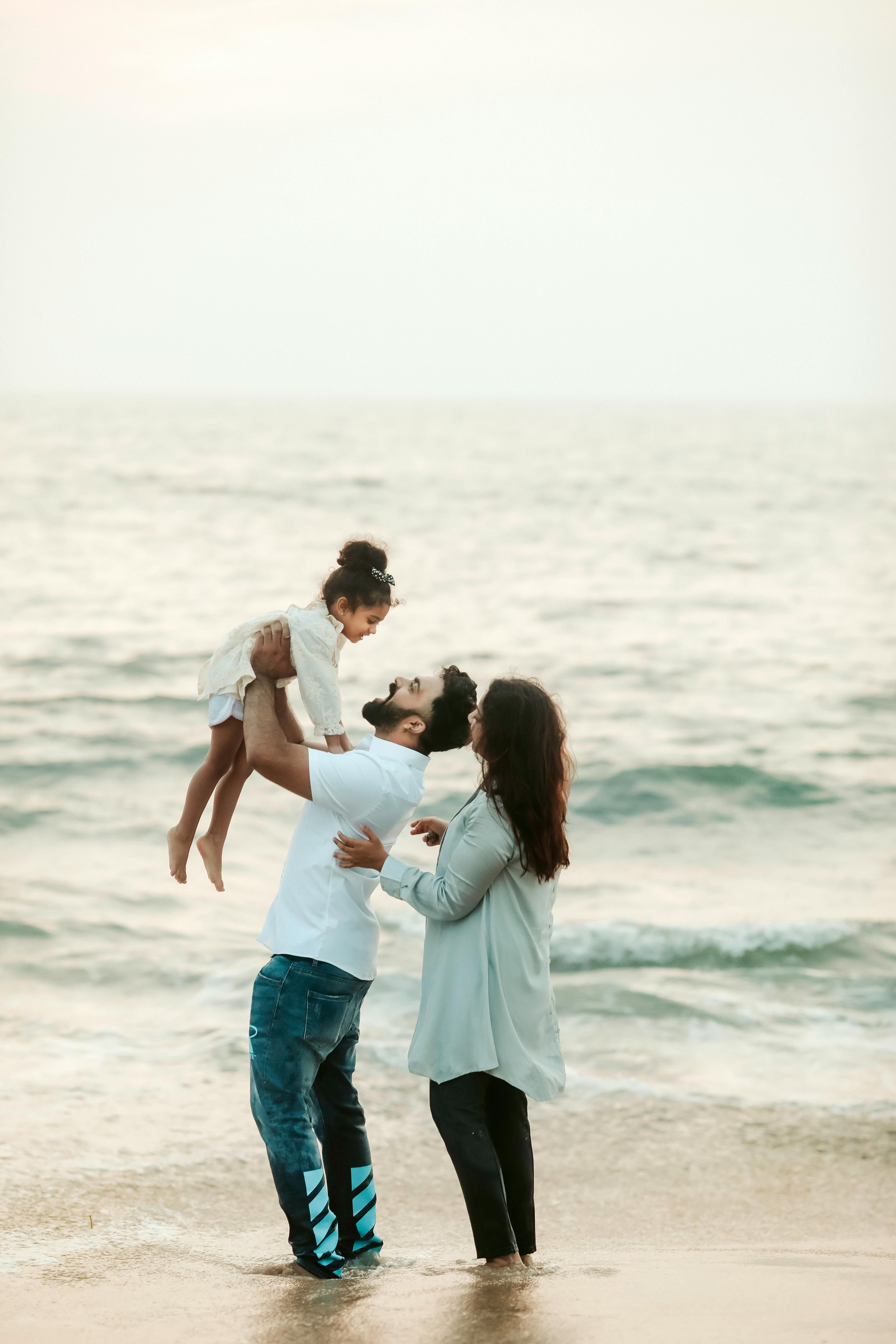 A couple and their daughter at the beach | Source: Pexels