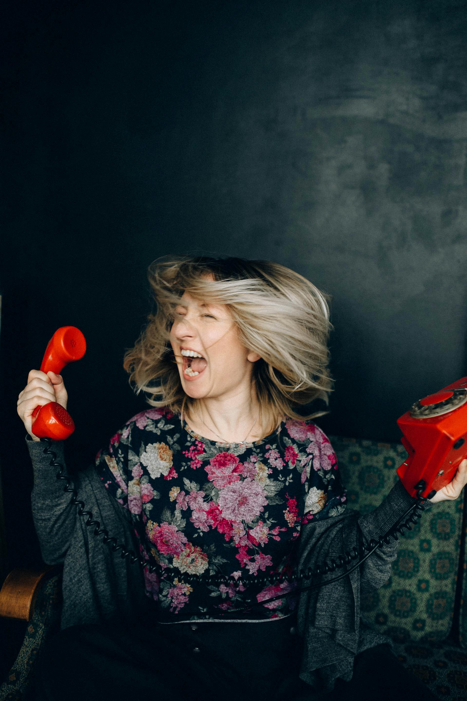 A woman yells while holding a telephone set | Source: Pexels