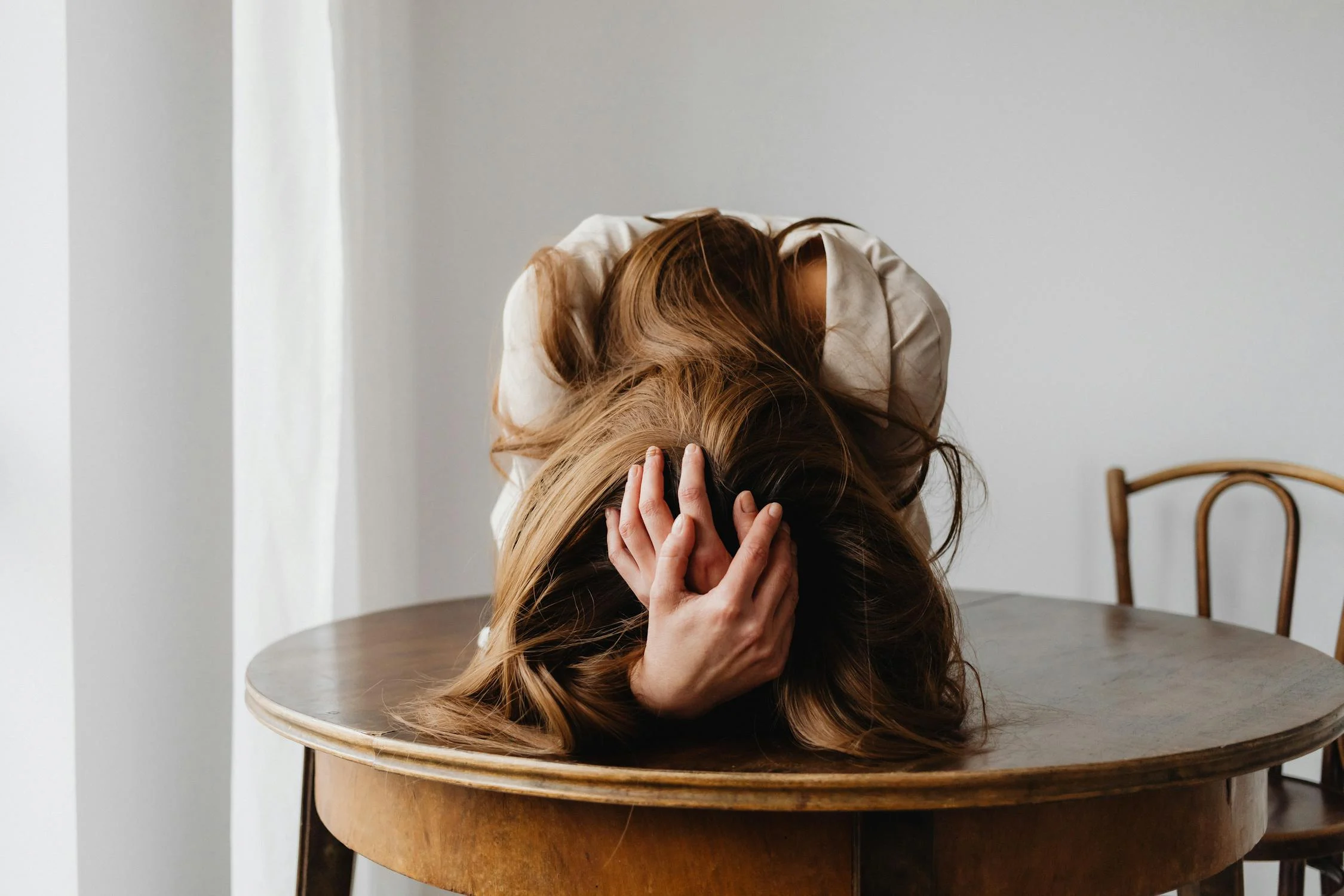 A tired woman holding her head | Source: Pexels