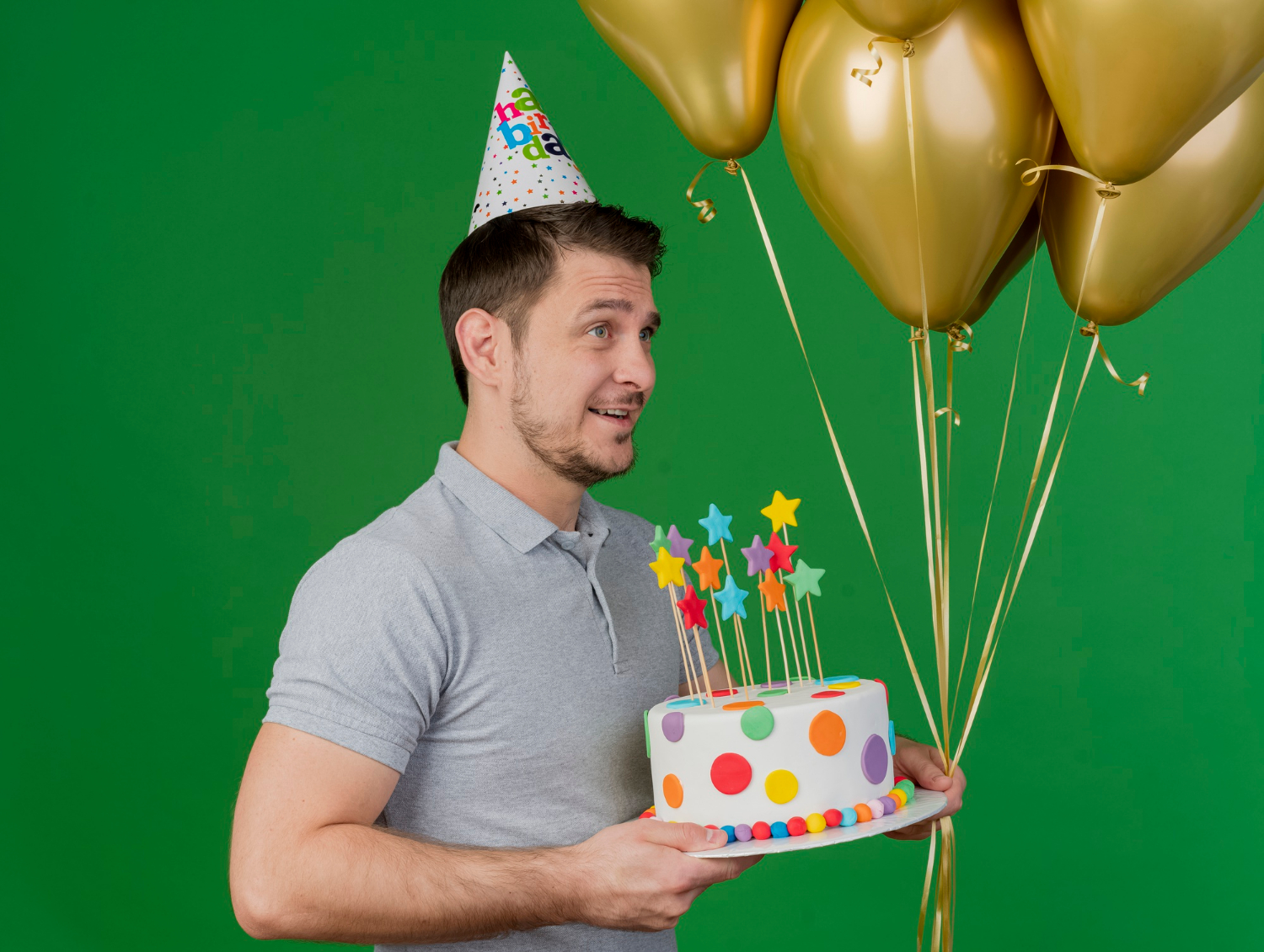 A delighted man holding balloons and a birthday cake | Source: Freepik