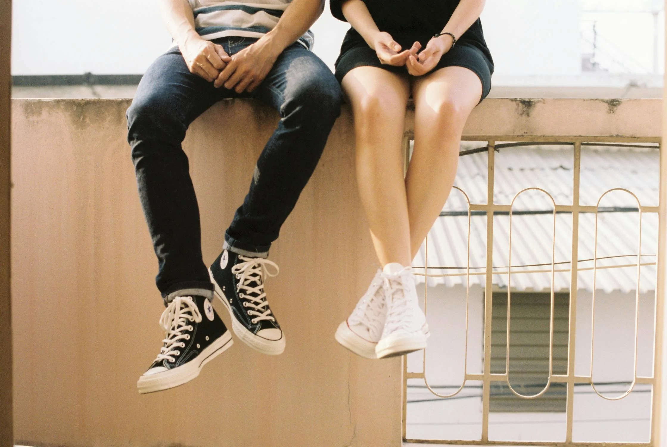 A couple sitting on a fence | Source: Pexels