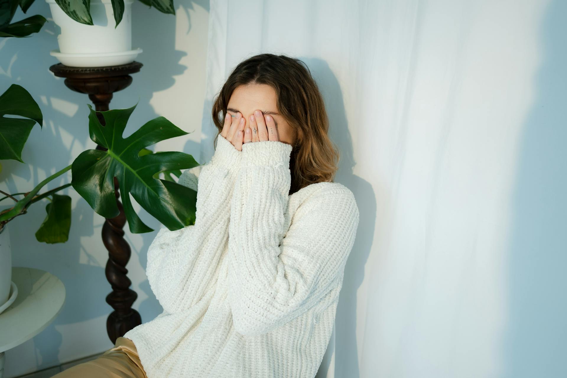 A woman covering her face with her hands | Source: Pexels