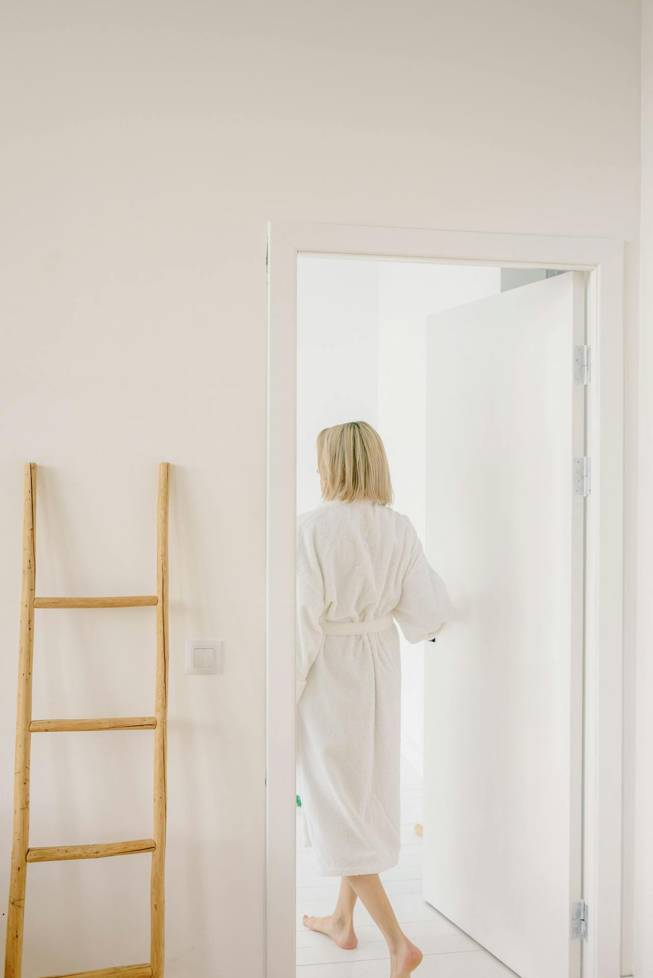 A woman in a bathrobe standing at the doorway | Source: Pexels