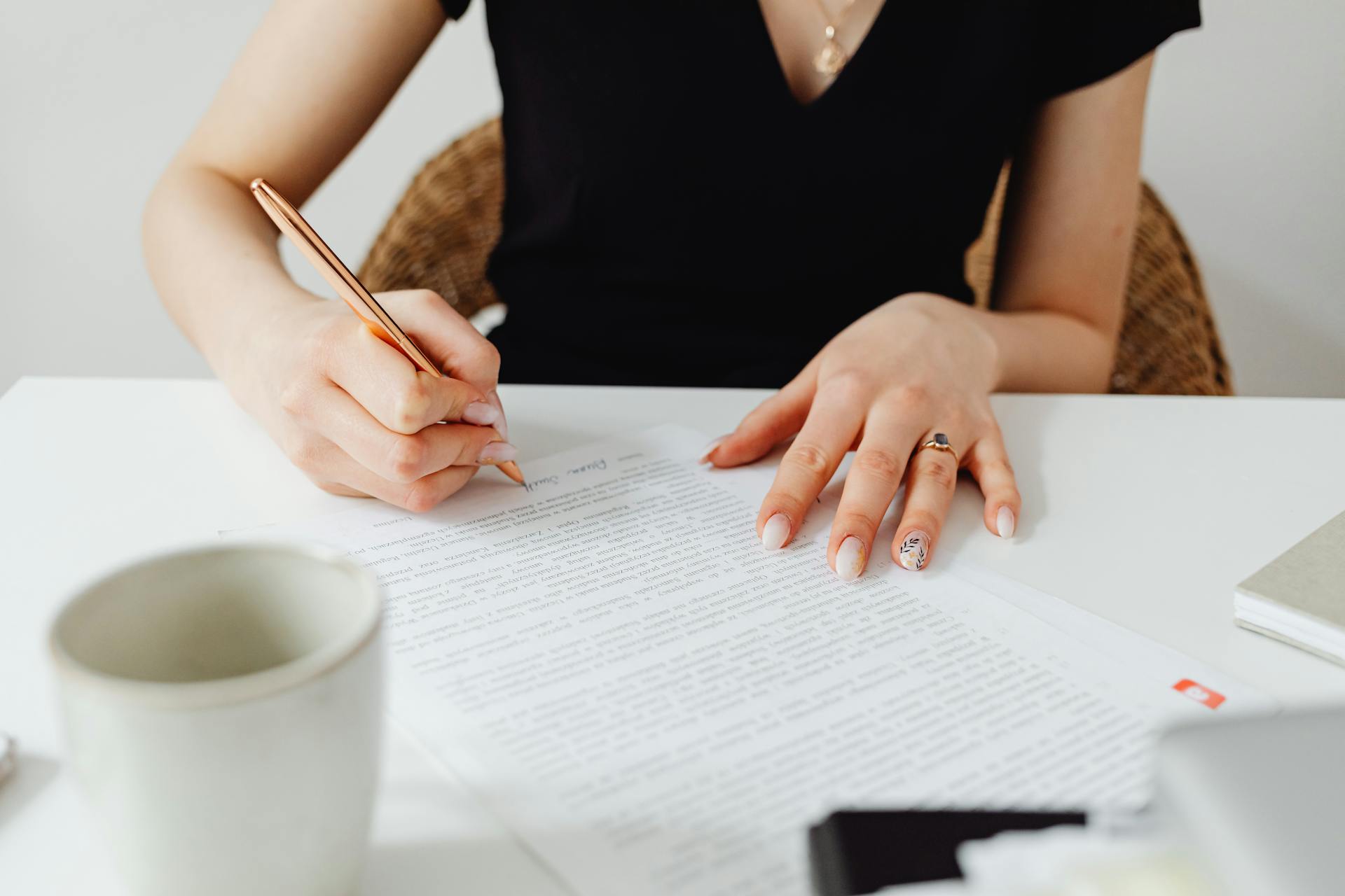 A woman signing a document | Source: Pexels