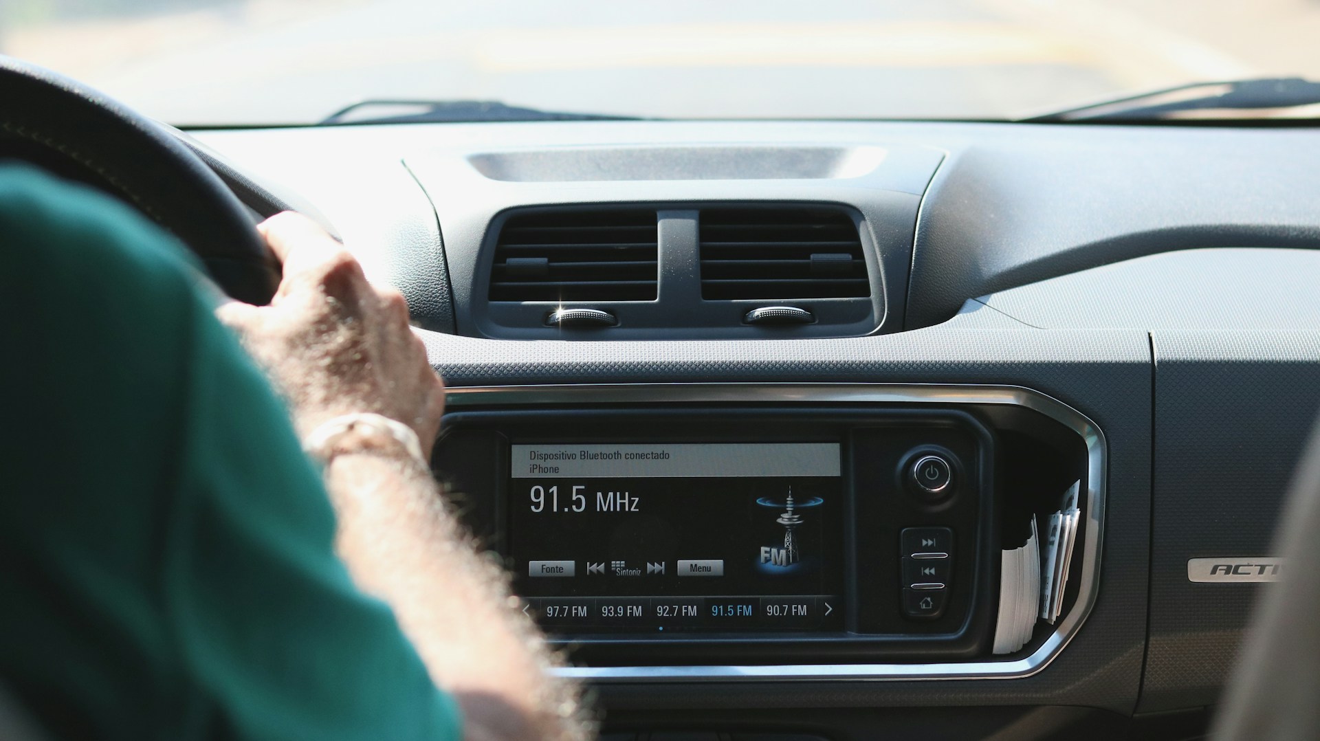 A man driving while listening to his car radio | Source: Unsplash