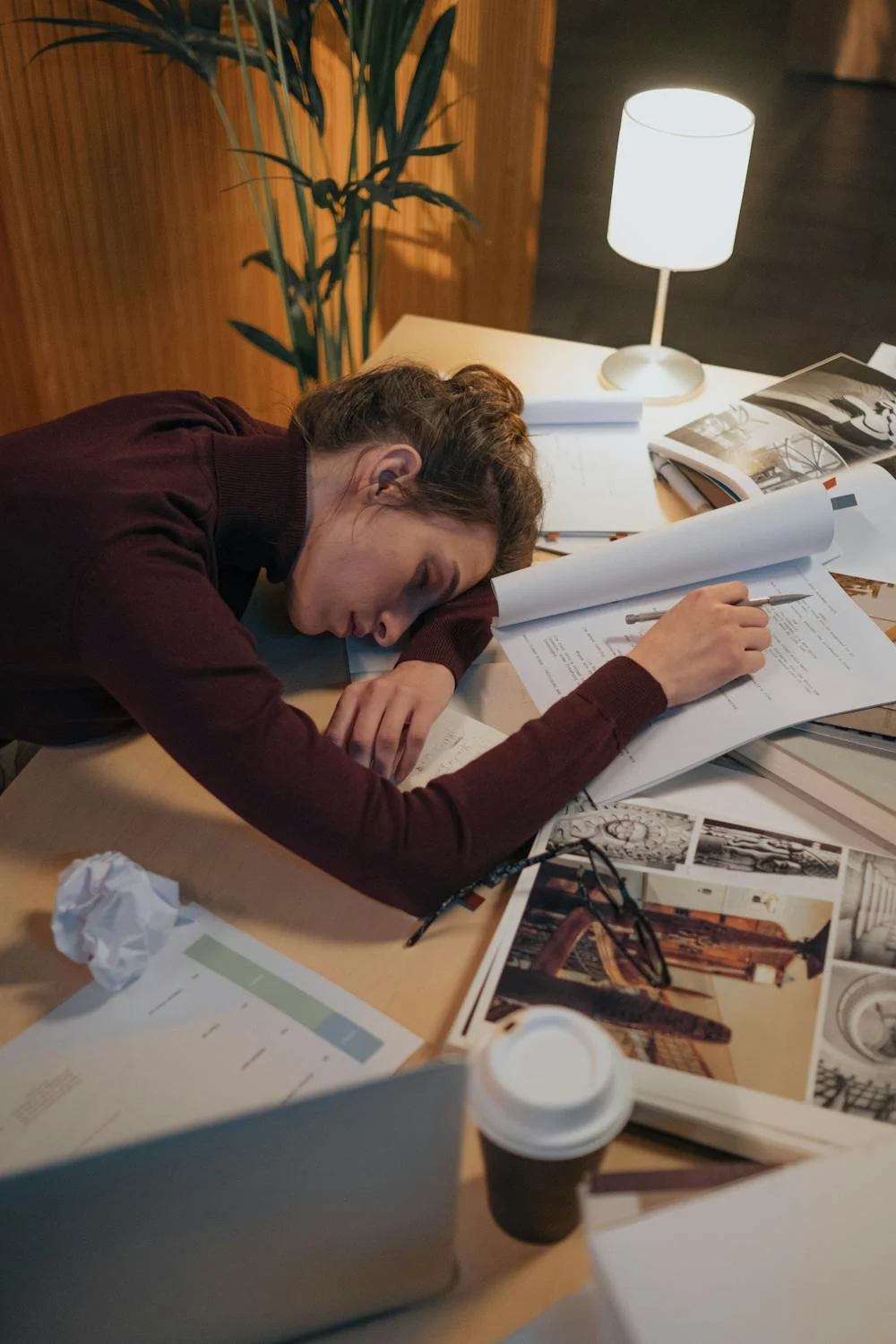 A tired woman sleeping on her table ⏐ Source: Pexels