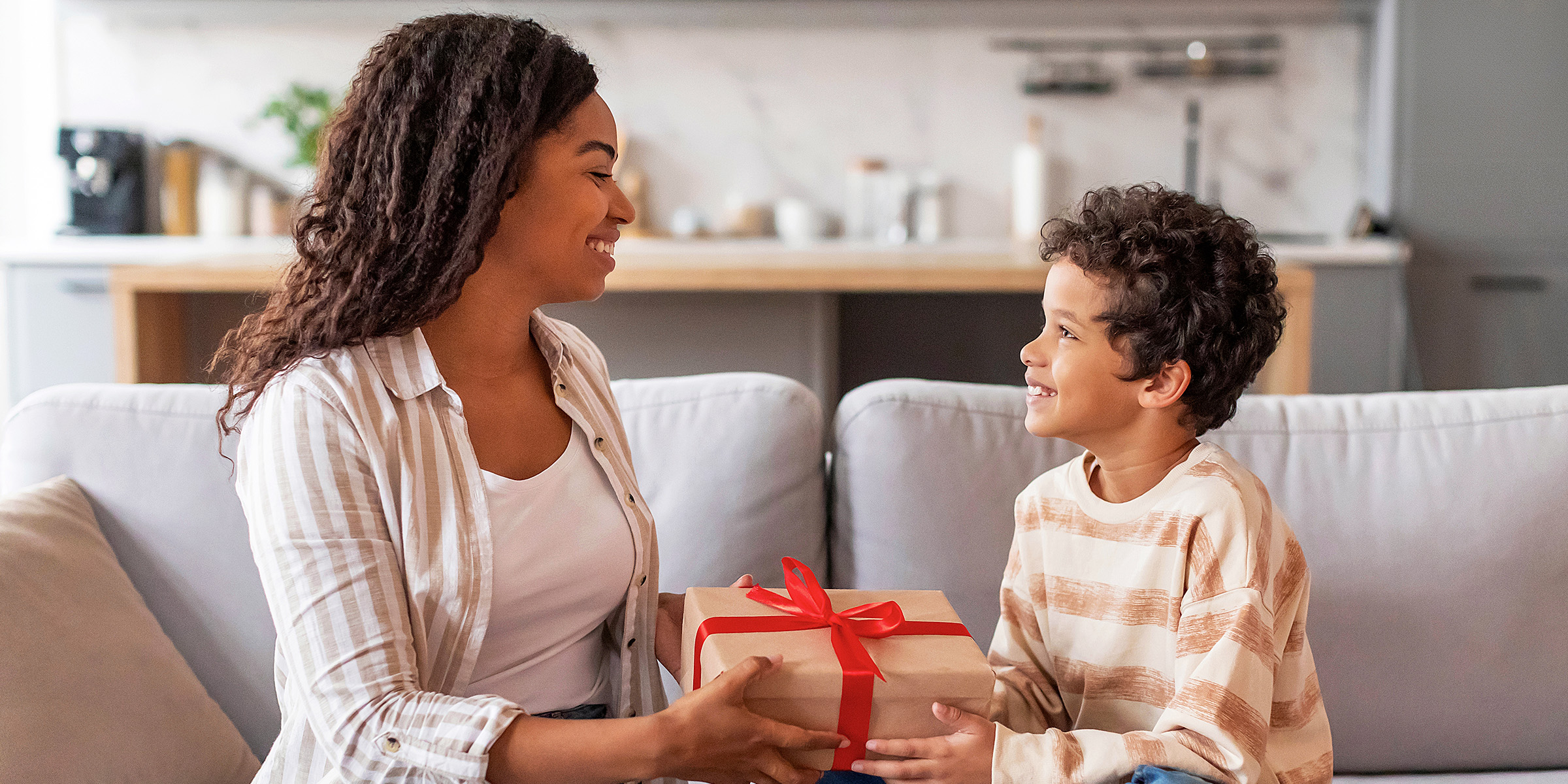 A woman giving a present to a young boy | Source: Shutterstock