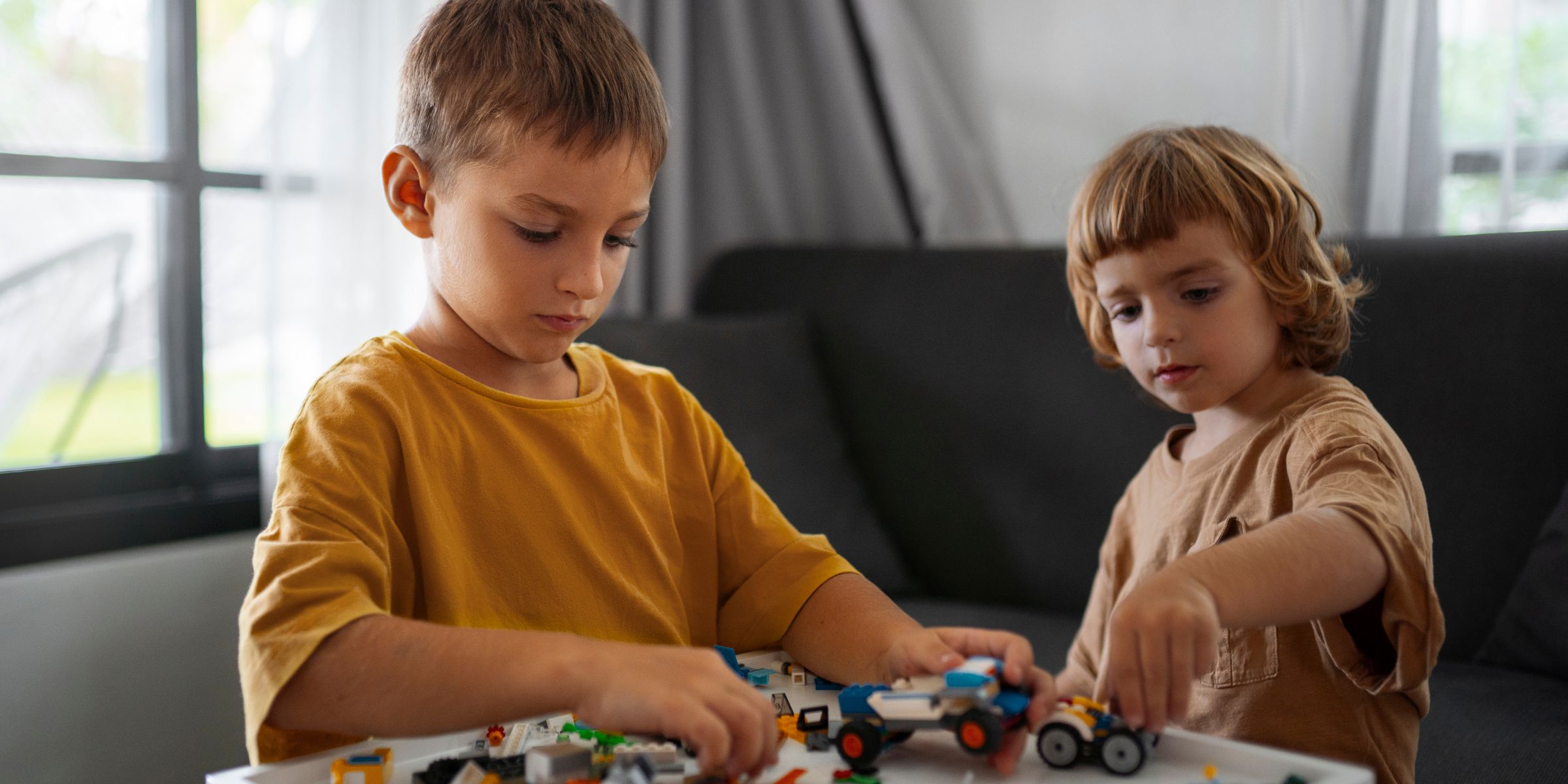 Two little kids playing with their toys | Source: Magnific