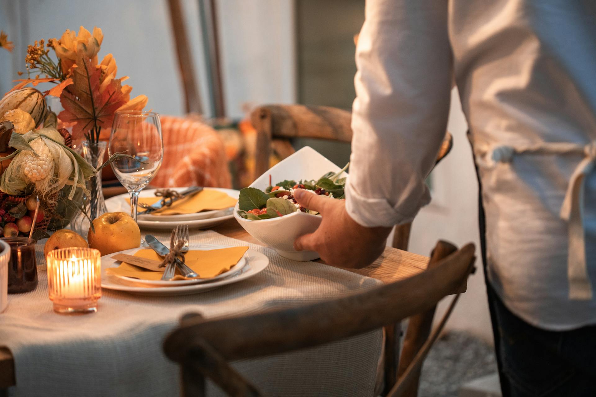 A person in a white dress shirt holding a white ceramic plate with food | Source: Pexels