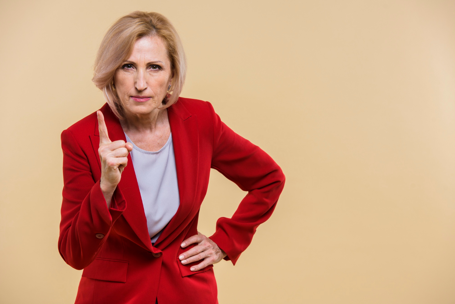 A serious senior woman pointing her finger | Source: Freepik