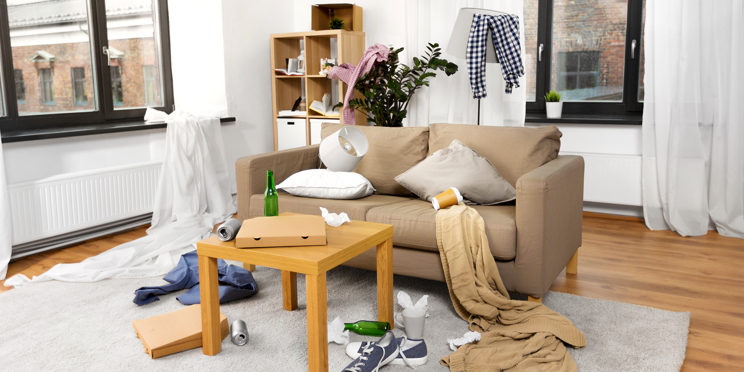 A messy living room with takeout boxes, clothes, and trash scattered around | Source: Shutterstock