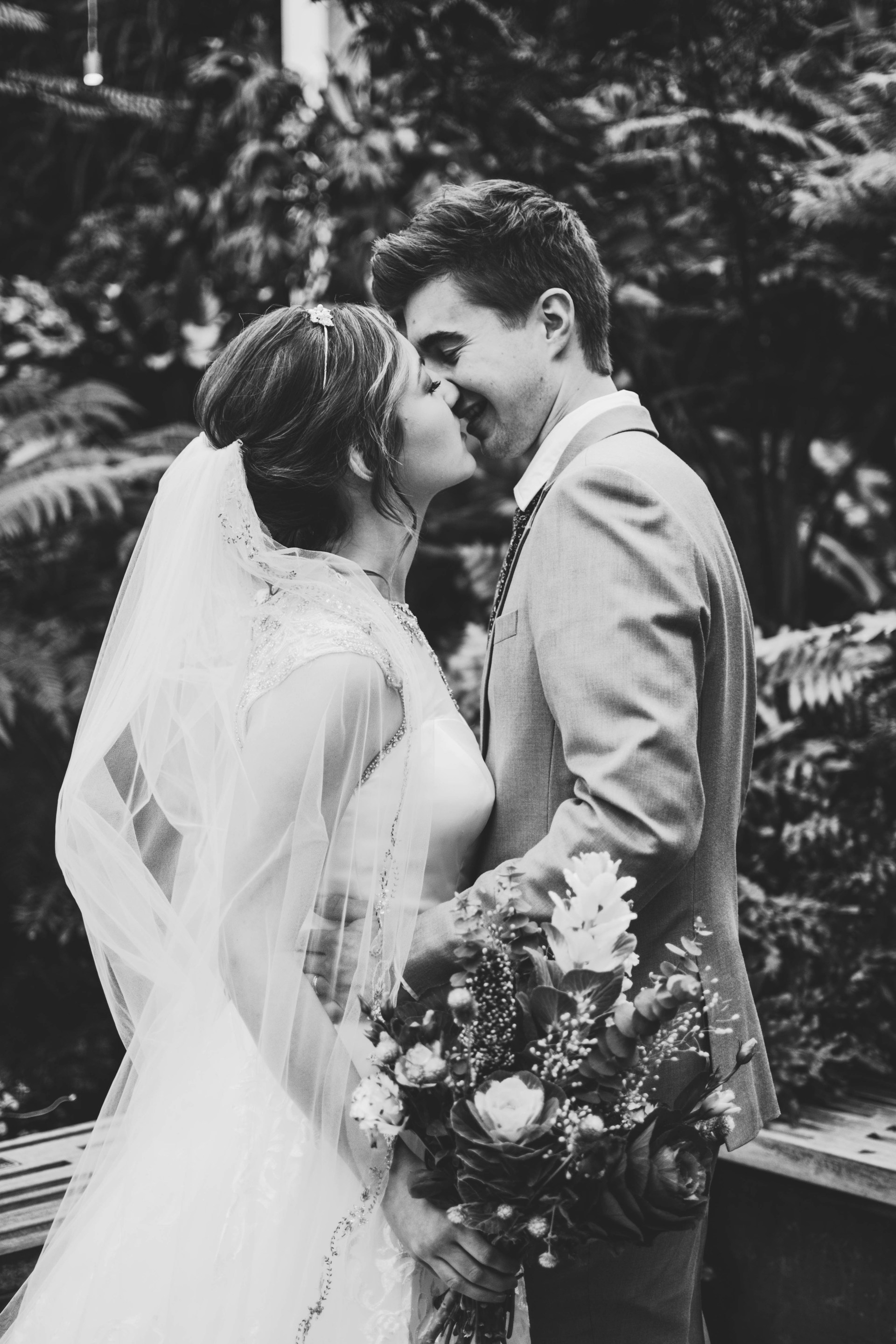 Grayscale shot of a newlywed couple locking lips | Source: Unsplash