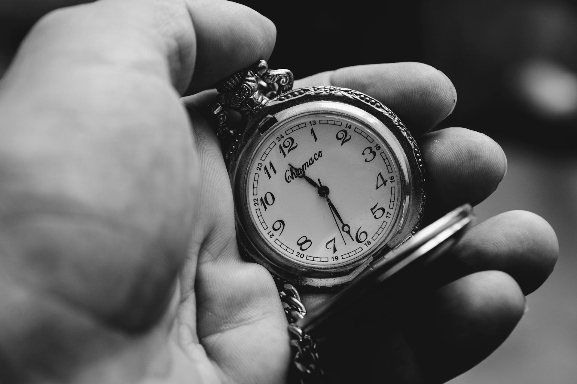 Grayscale shot of a person holding a vintage pocket watch | Source: Pexels