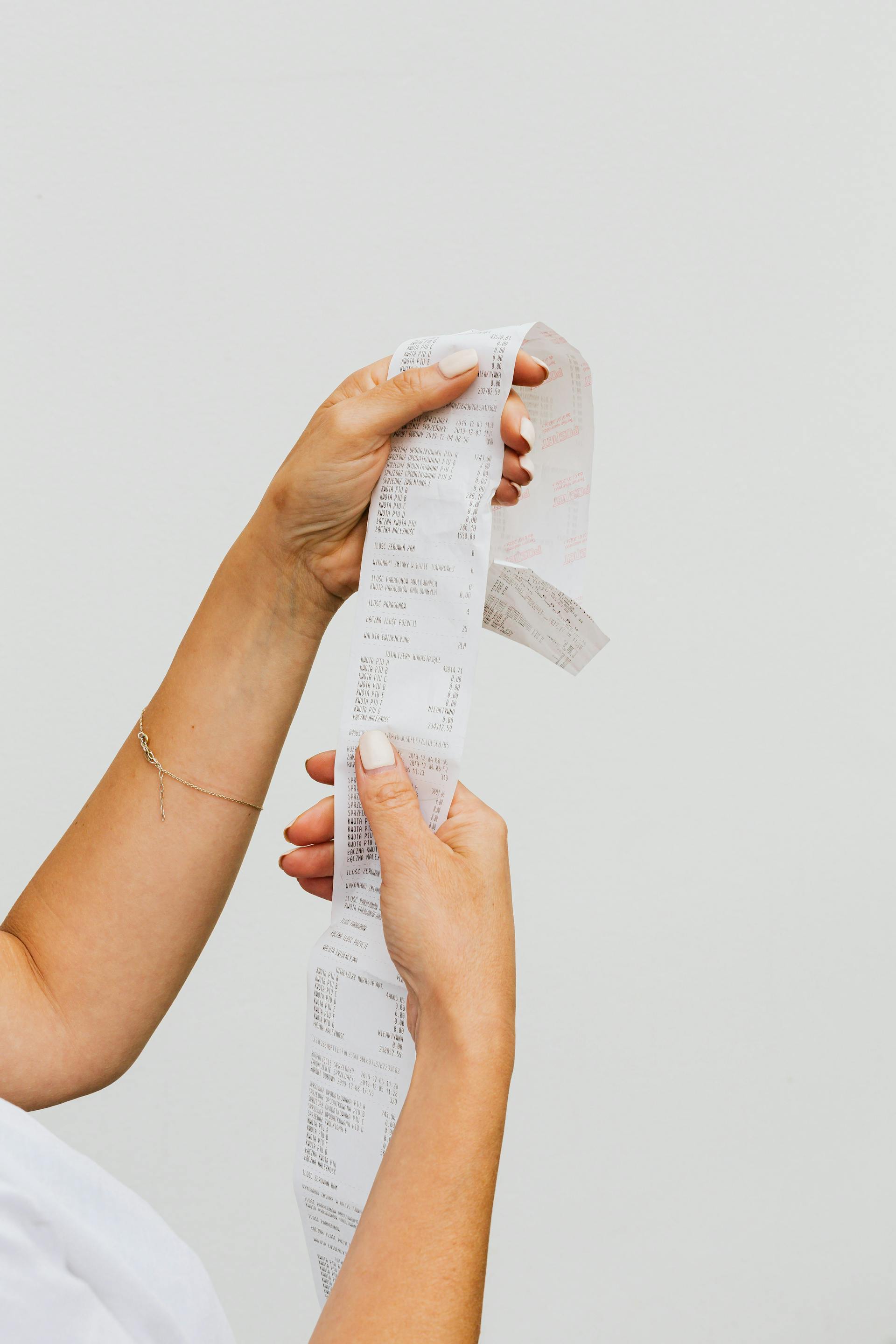 A woman holding up a receipt | Source: Pexels
