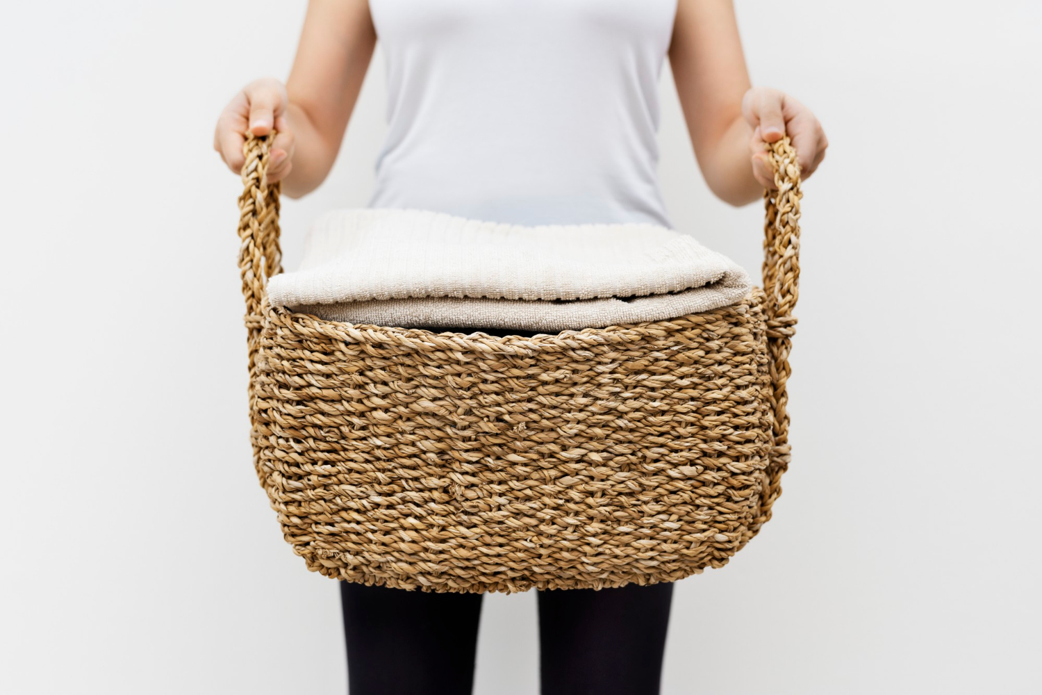 A woman holding a laundry basket | Source: Freepik