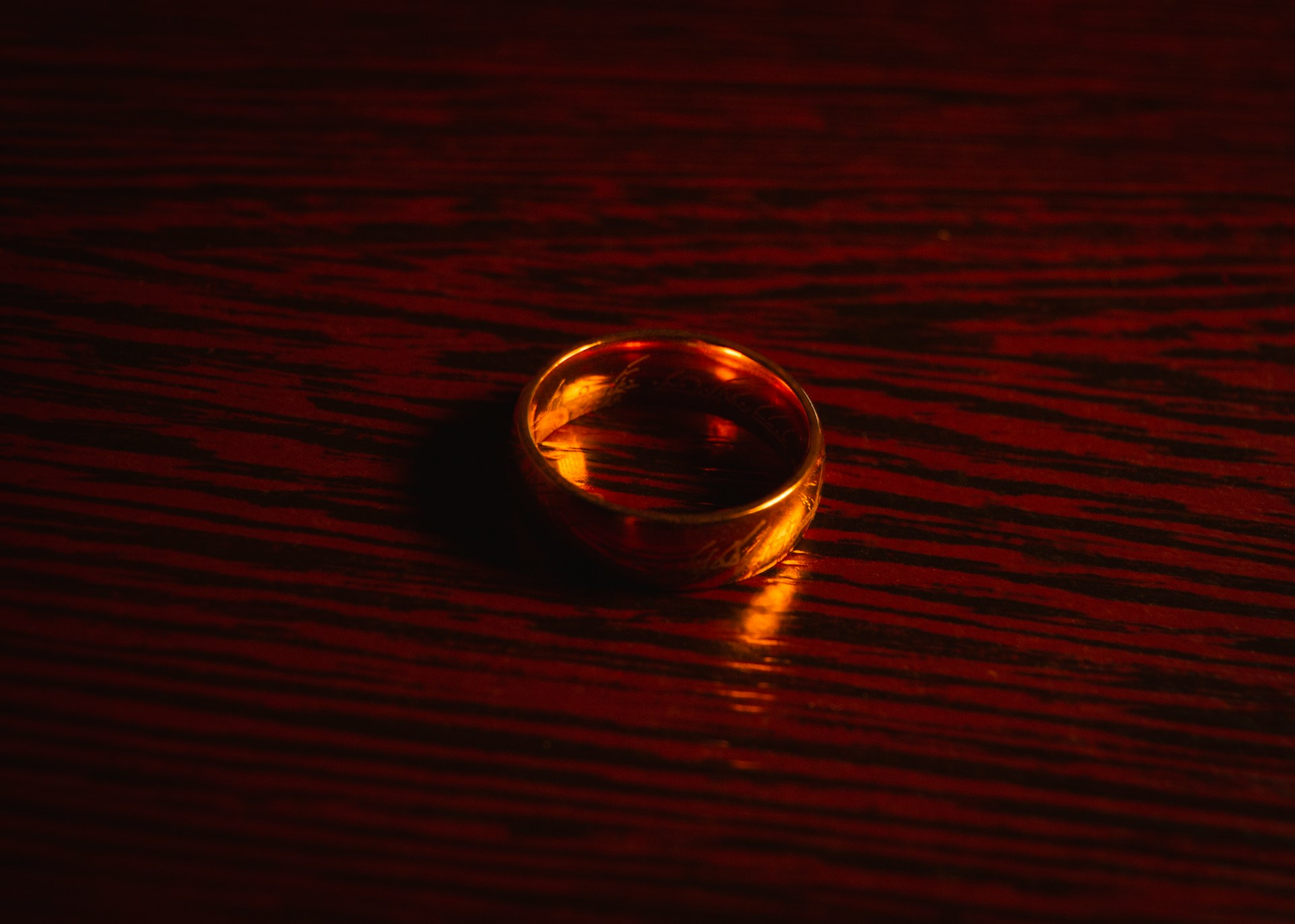 Close-up shot of a gold ring on a brown wooden surface | Source: Unsplash