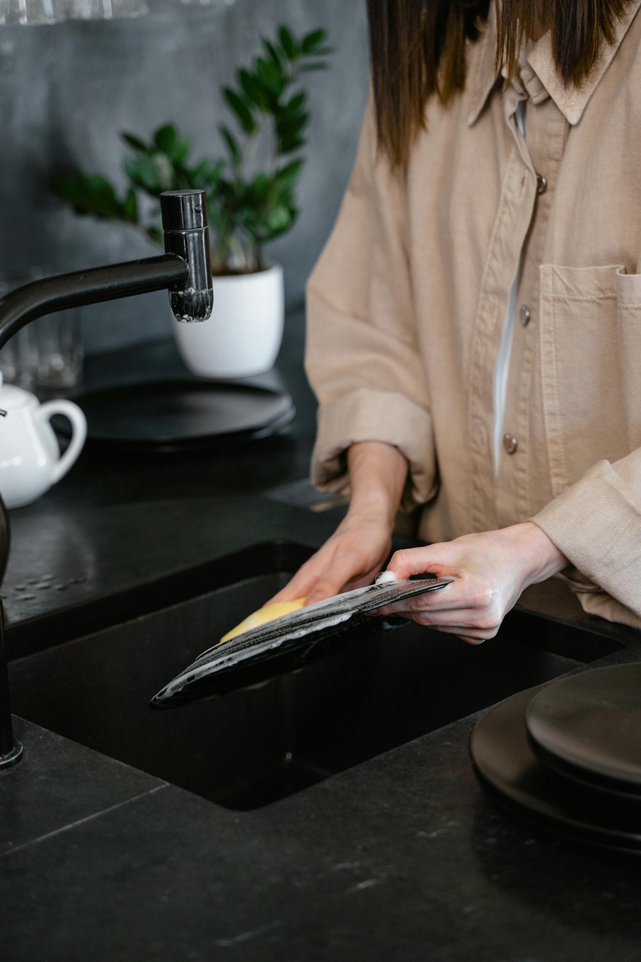 A woman washing dishes | Source: Pexels