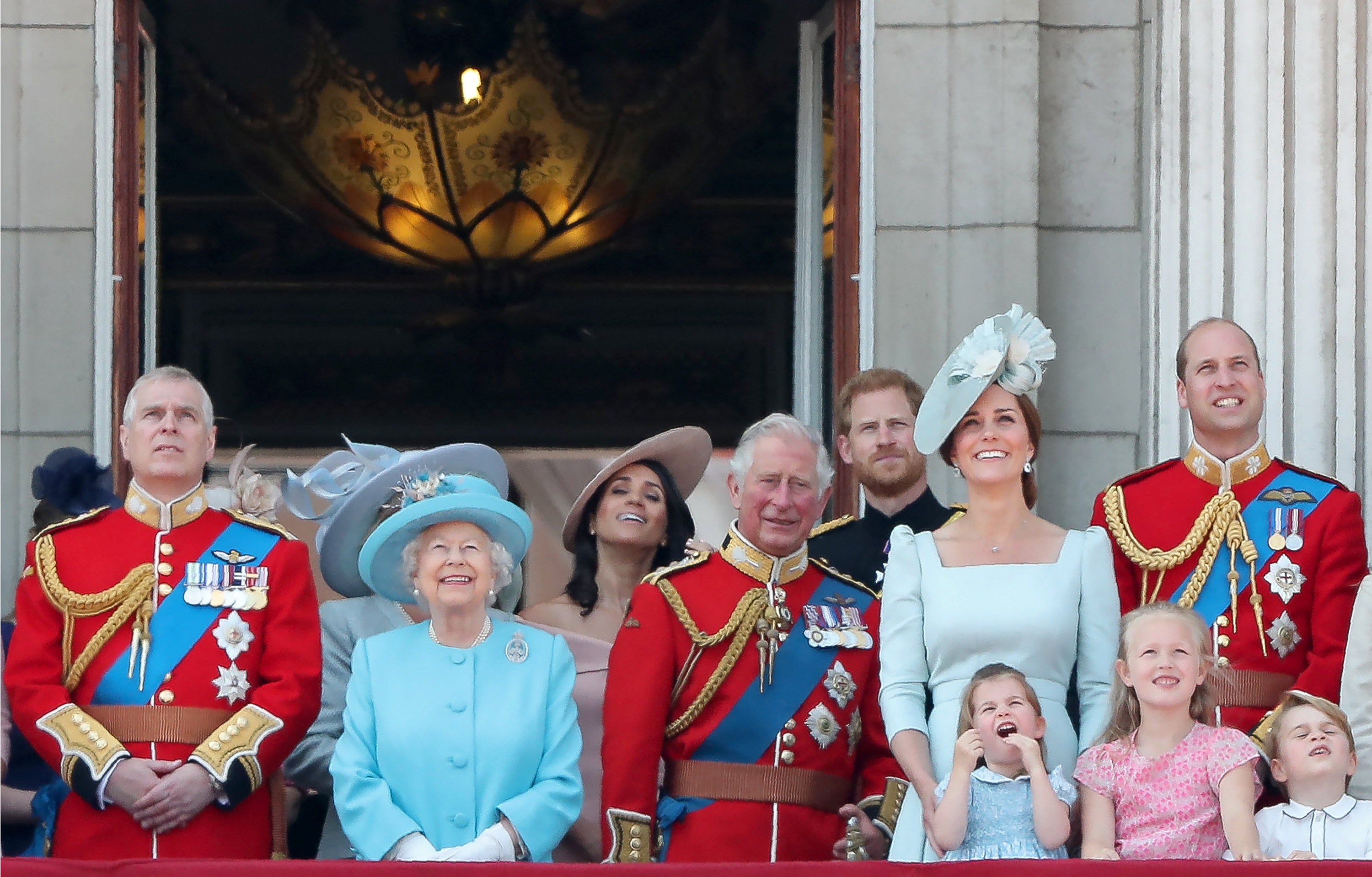Prince Andrew, Queen Elizabeth II, Meghan, Duchess of Sussex, Prince Charles, Prince Harry, Princess Catherine, Princess Charlotte, Prince George and Prince William stand on the balcony of Buckingham Palace to watch a fly-past of aircraft by the Royal Air Force, in London on June 9, 2018. | Source: Getty Images