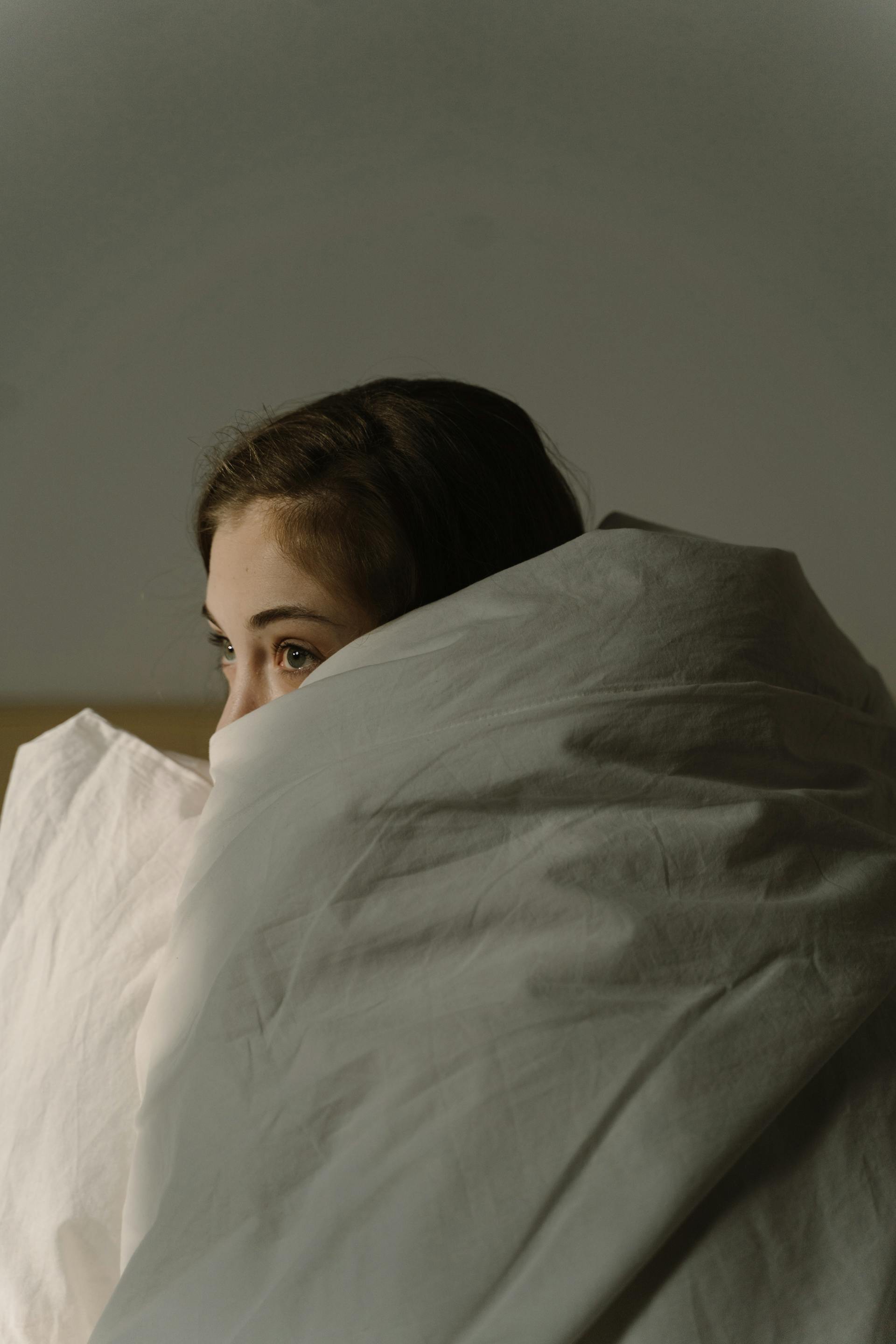 Woman hiding under blanket | Source: Pexels