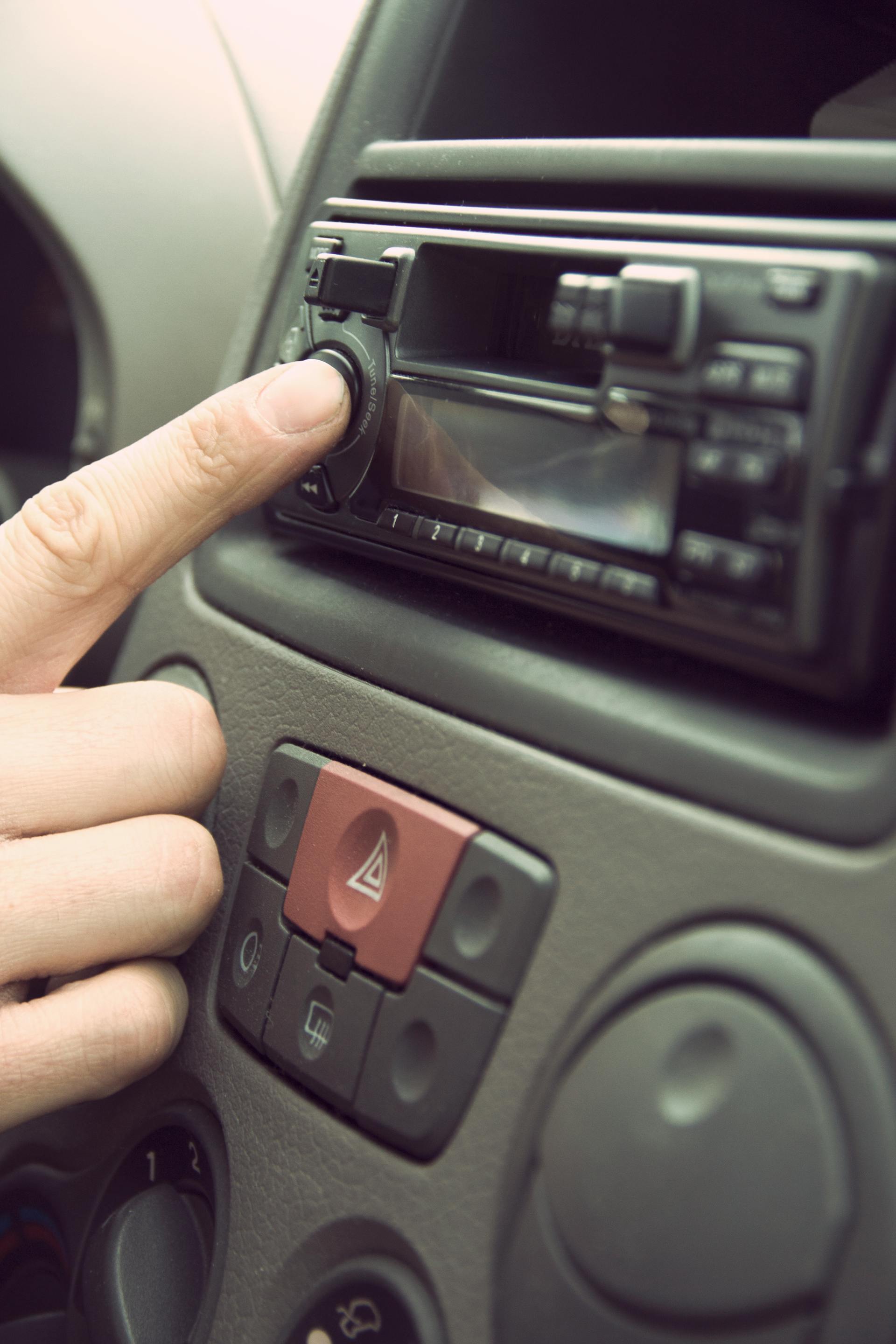 A person pressing a button on a car radio | Source: Pexels