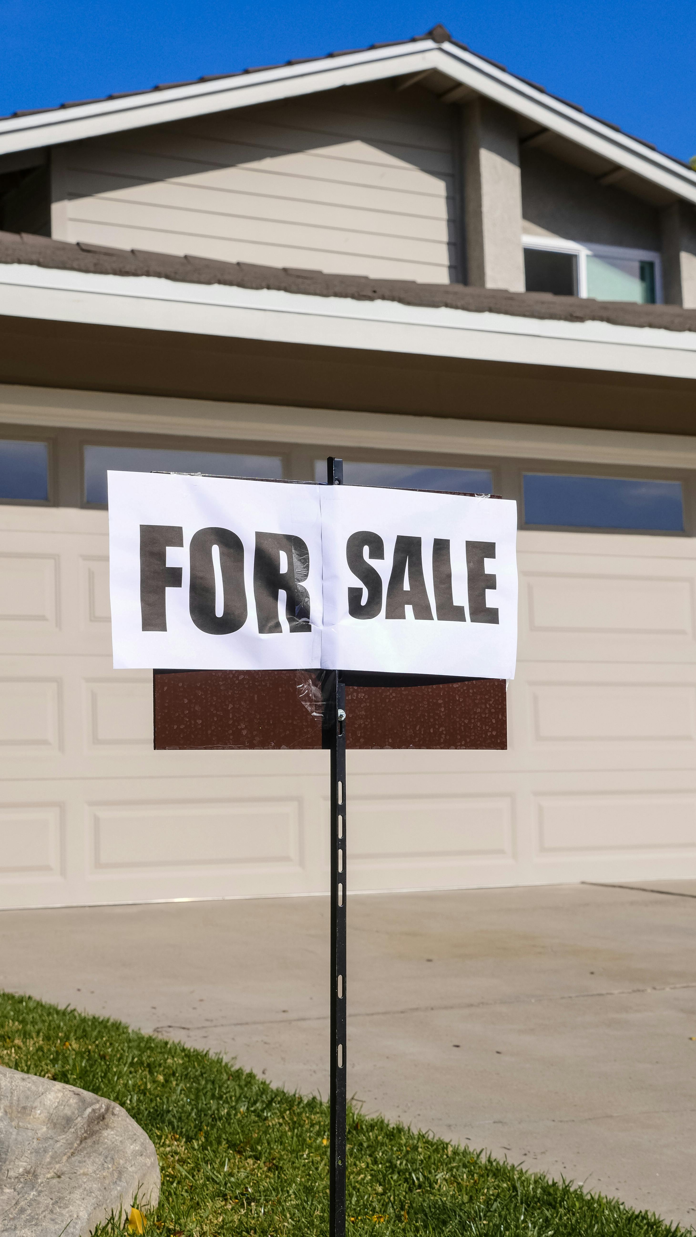 A "For Sale" sign in front of a house | Source: Pexels