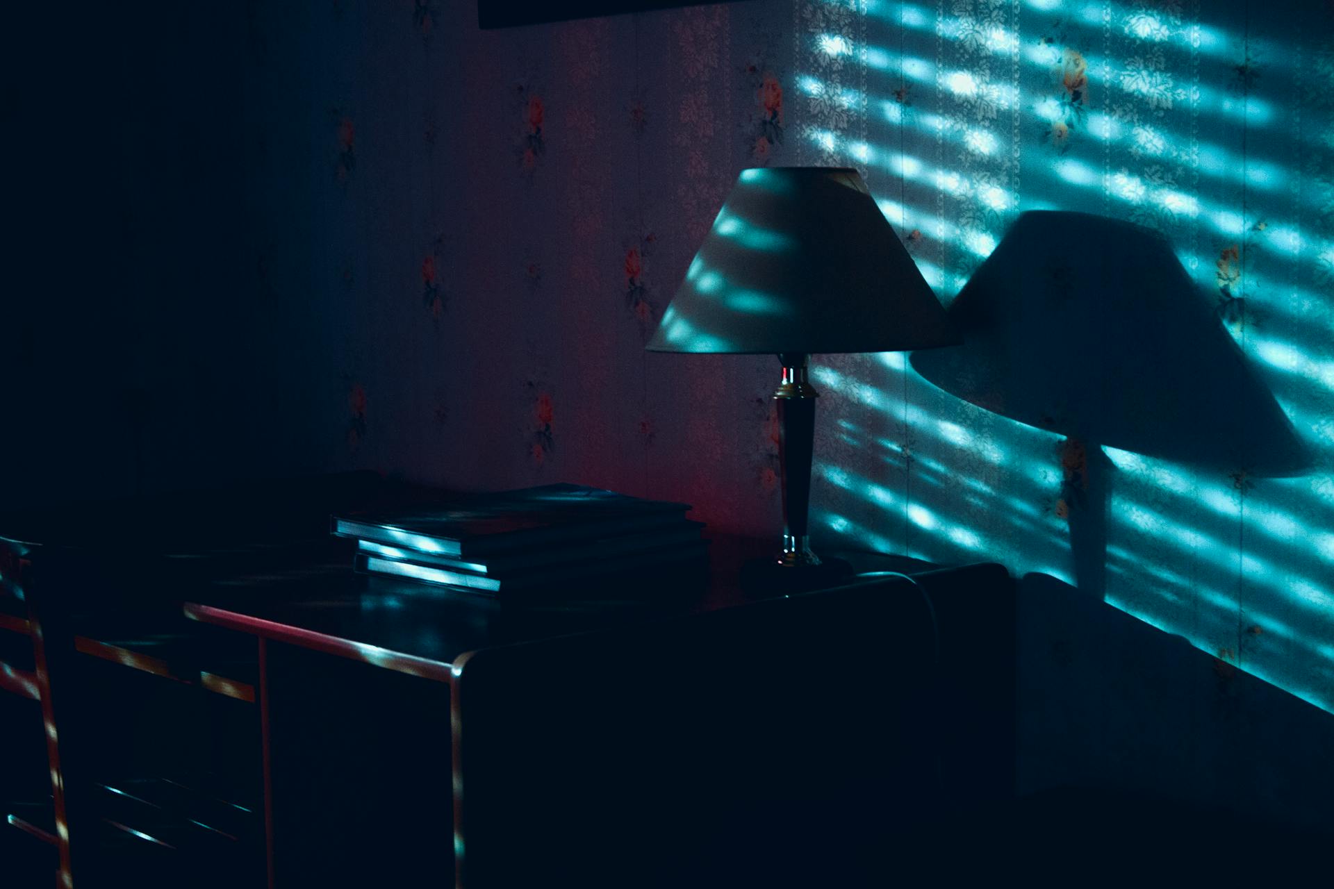 Shadows surrounding a nightstand in a dark bedroom | Source: Pexels