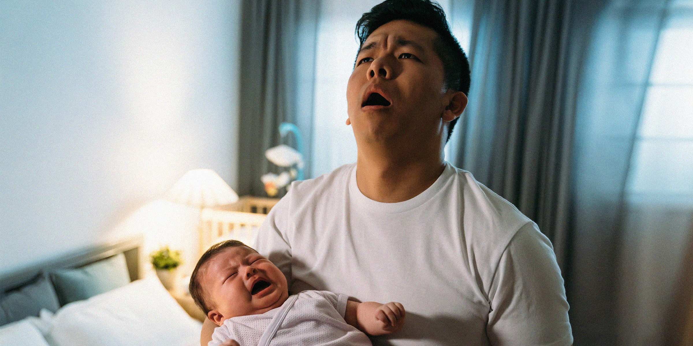 A desparate-looking man holding a baby | Source: Shutterstock