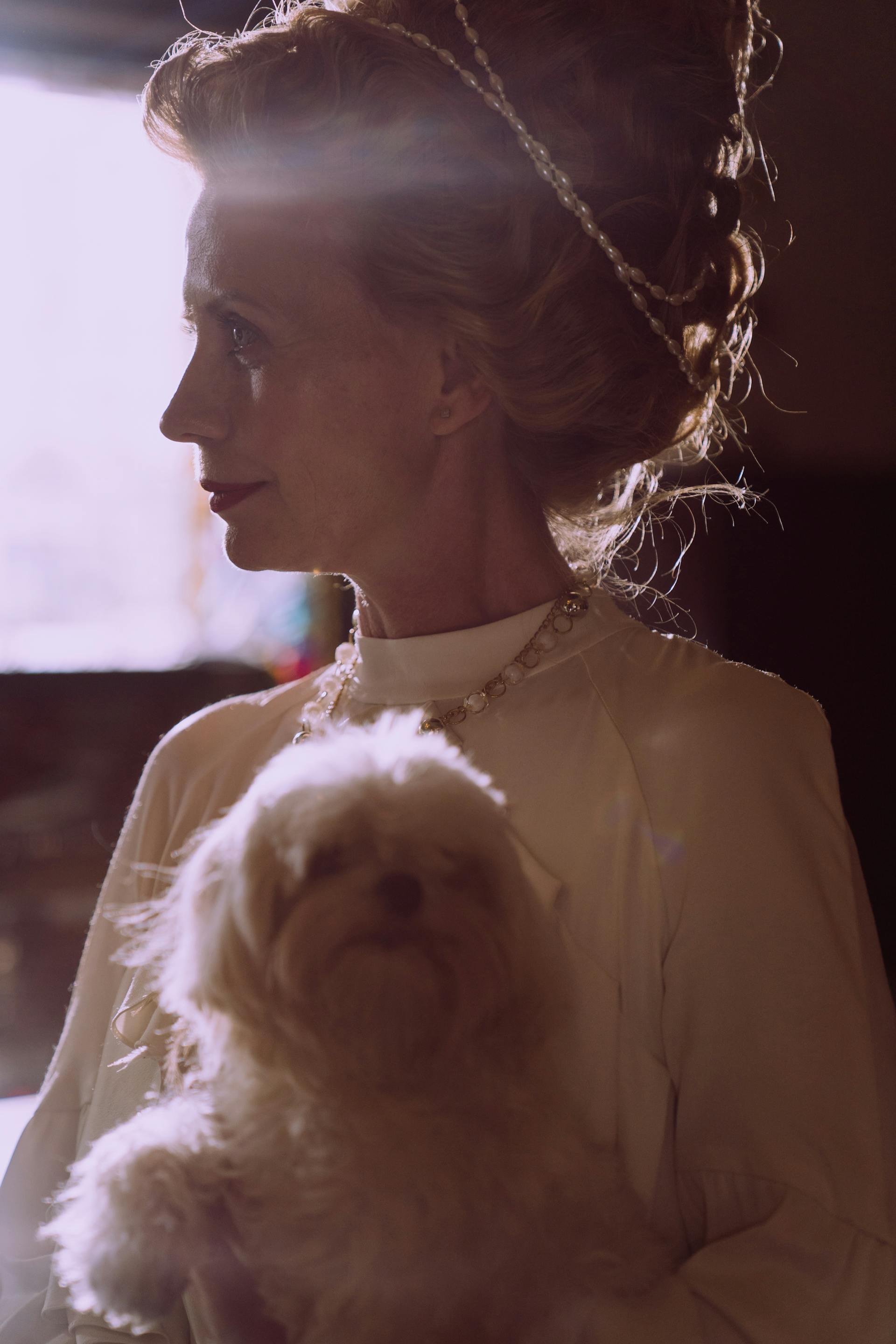 A middle-aged woman holding a dog | Source: Pexels
