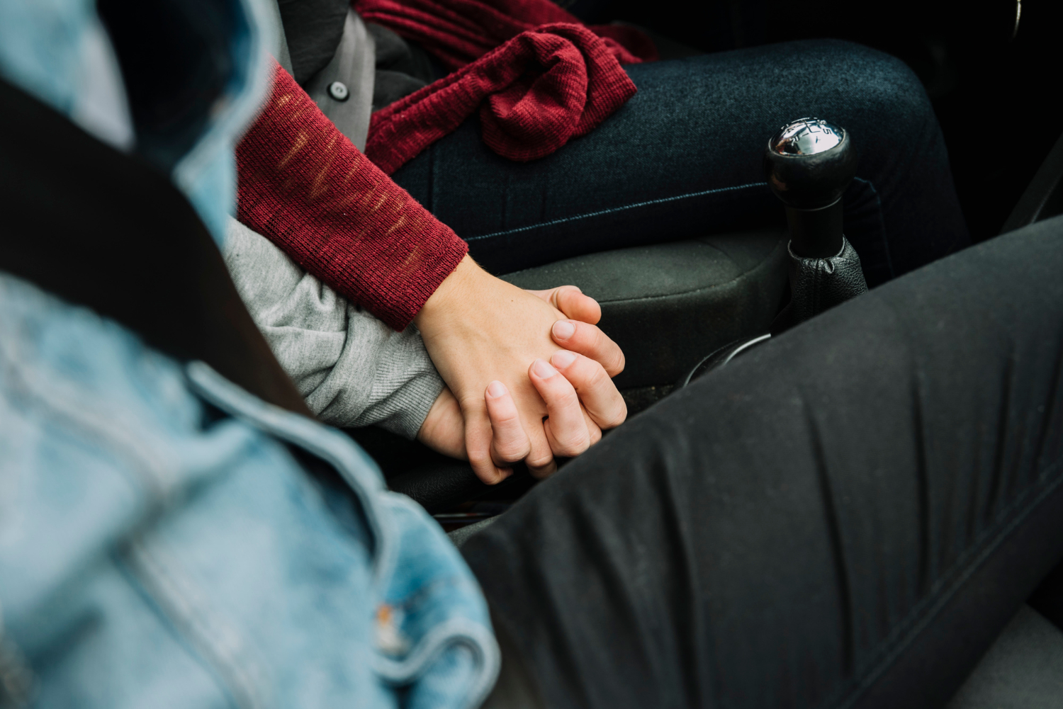 A couple sitting in the car and holding hands | Source: Freepik